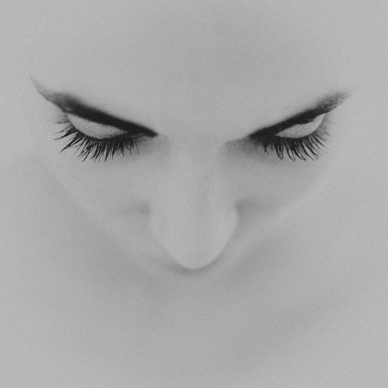 Close-up black and white details of eyes and facial features in an artistic composition.