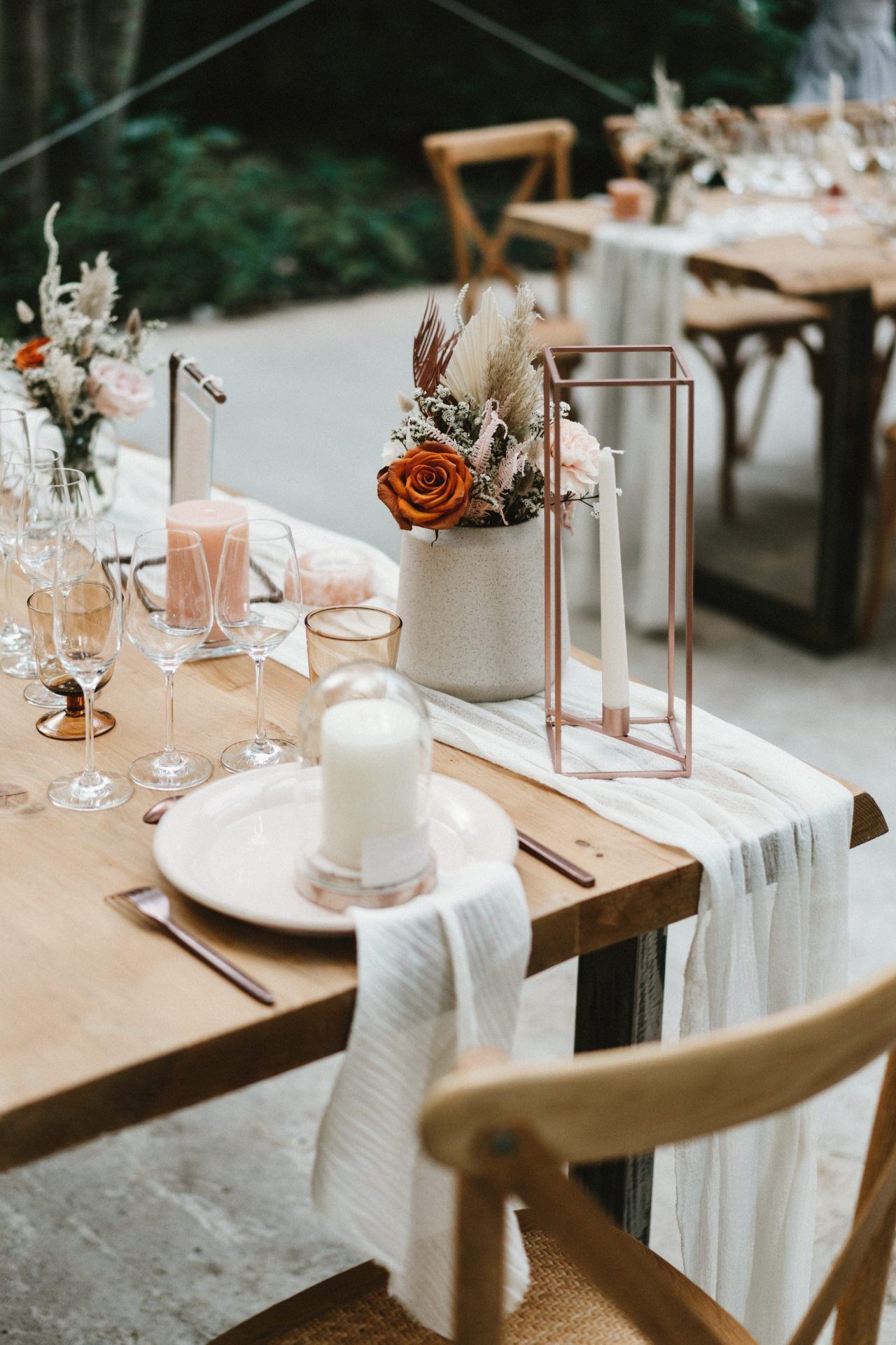 Elegant wedding reception table settings with floral centerpieces and glassware.