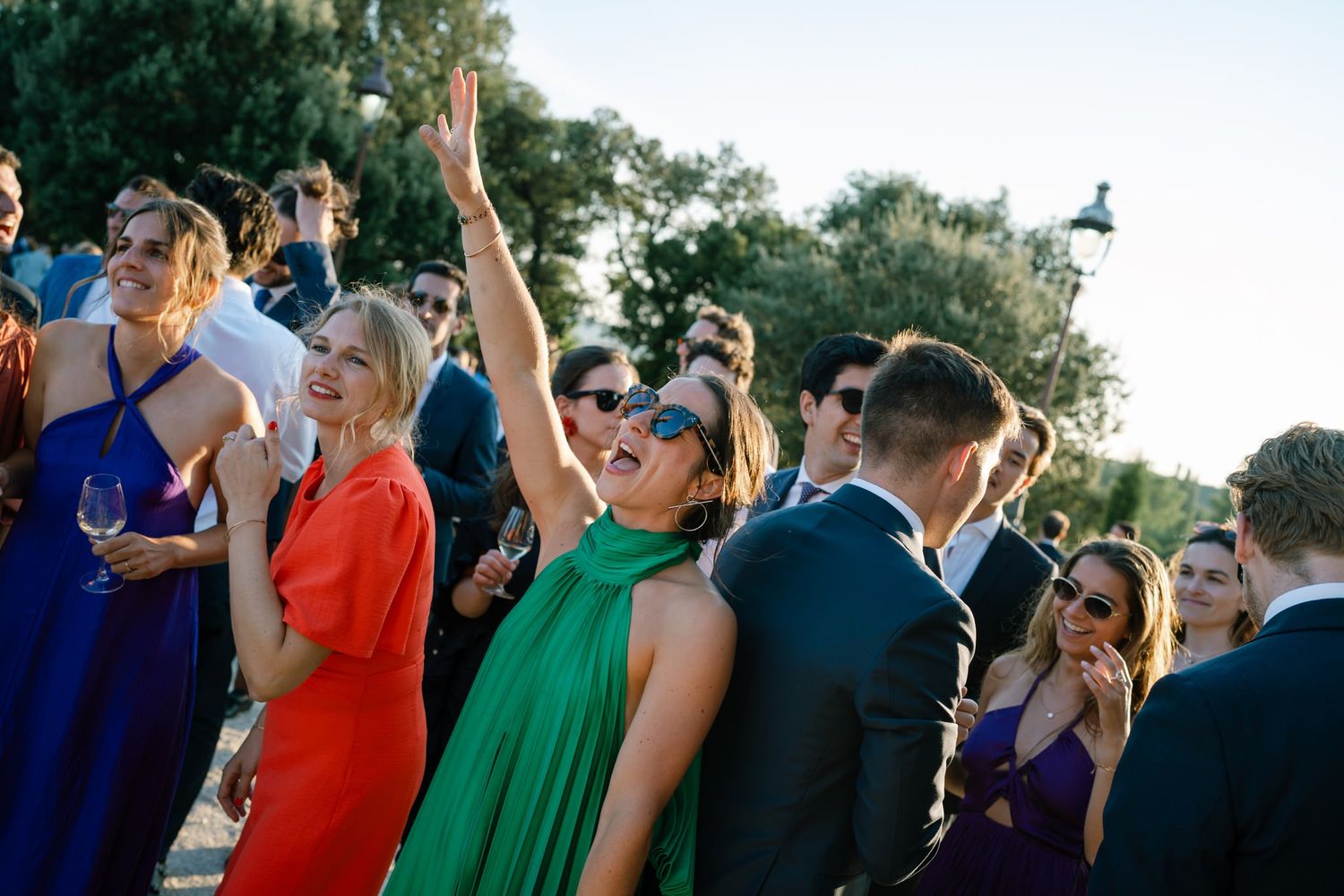 Wedding guests dancing and celebrating at outdoor reception.