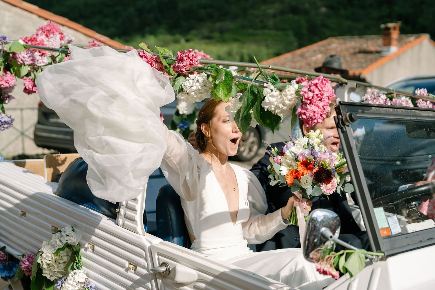 Wedding celebration with decorated vintage cars and floral arrangements.