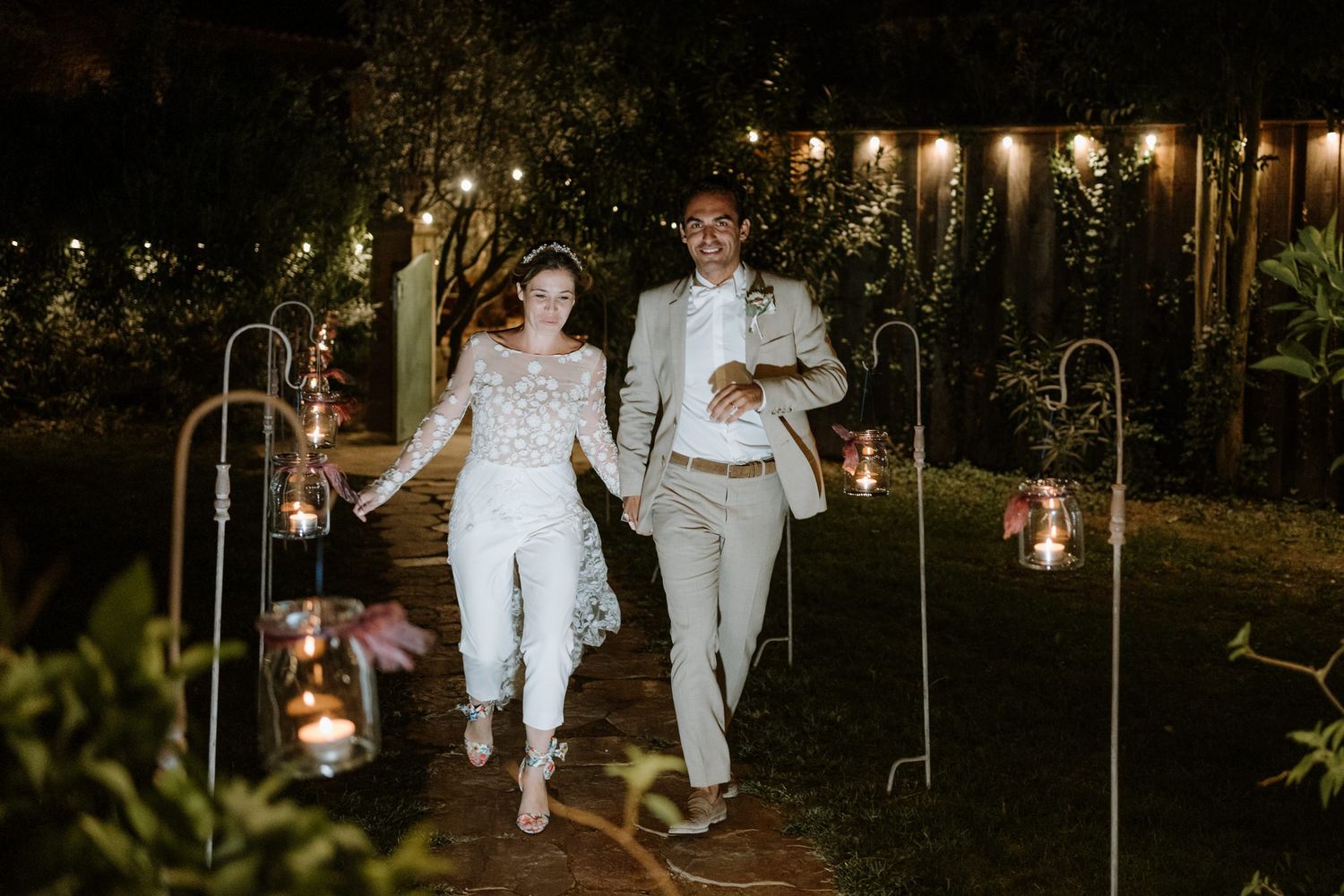 String lights illuminate an outdoor garden pathway at night creating a romantic atmosphere.