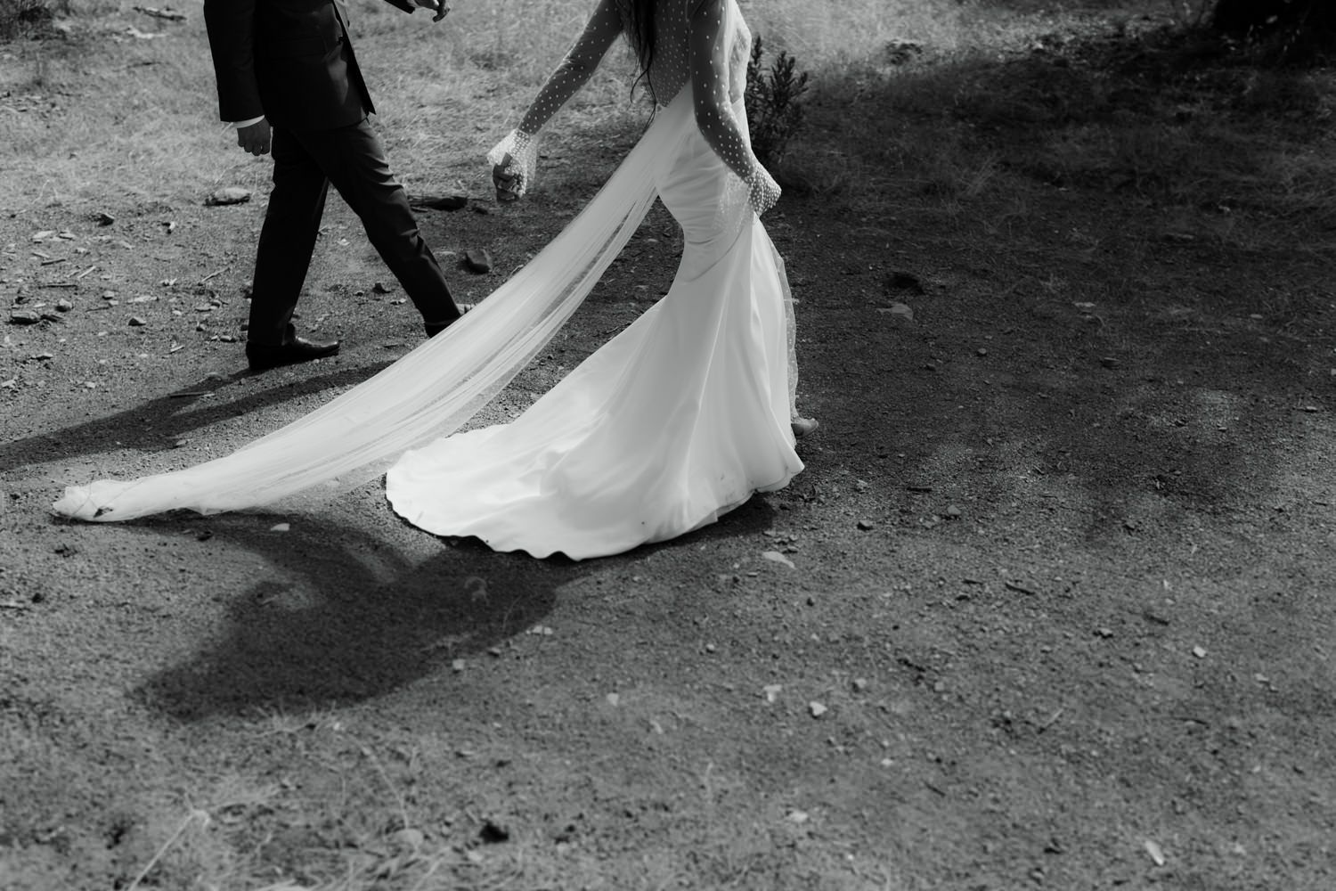 Black and white wedding photo showing the elegant flow of a bride's dress during a dance.