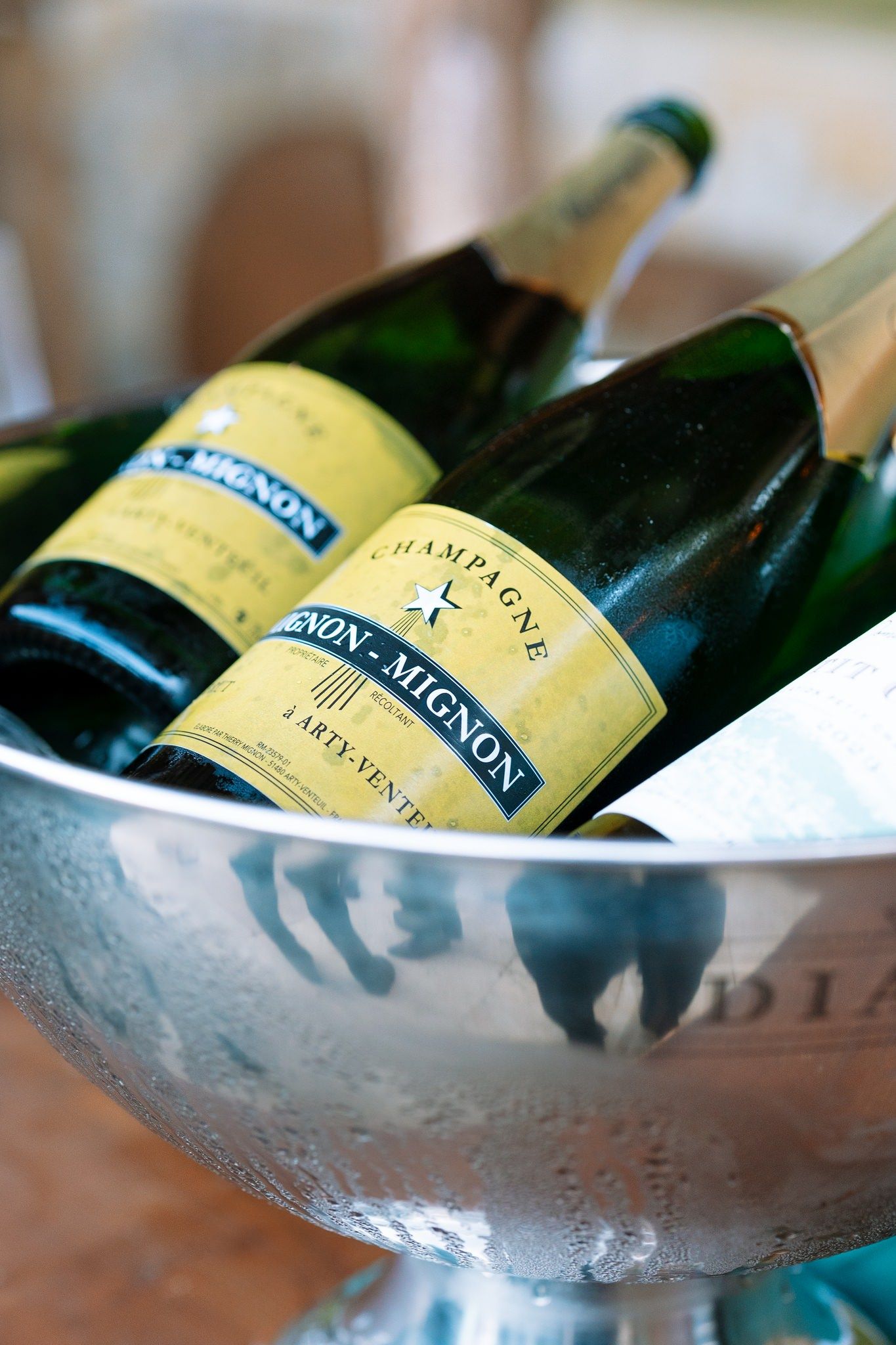 Champagne bottles chilling in silver ice bucket at event.