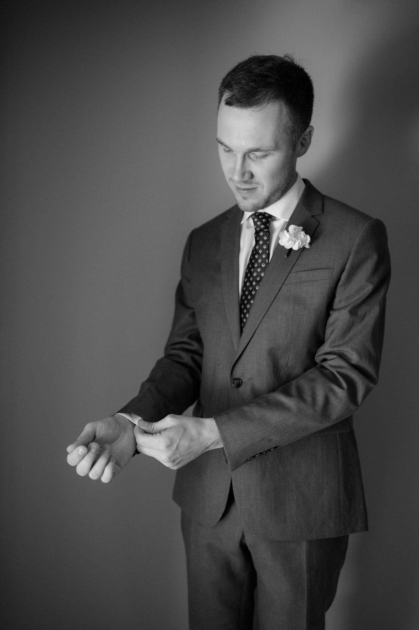 A series of black and white photos showing a man in a suit adjusting his tie.