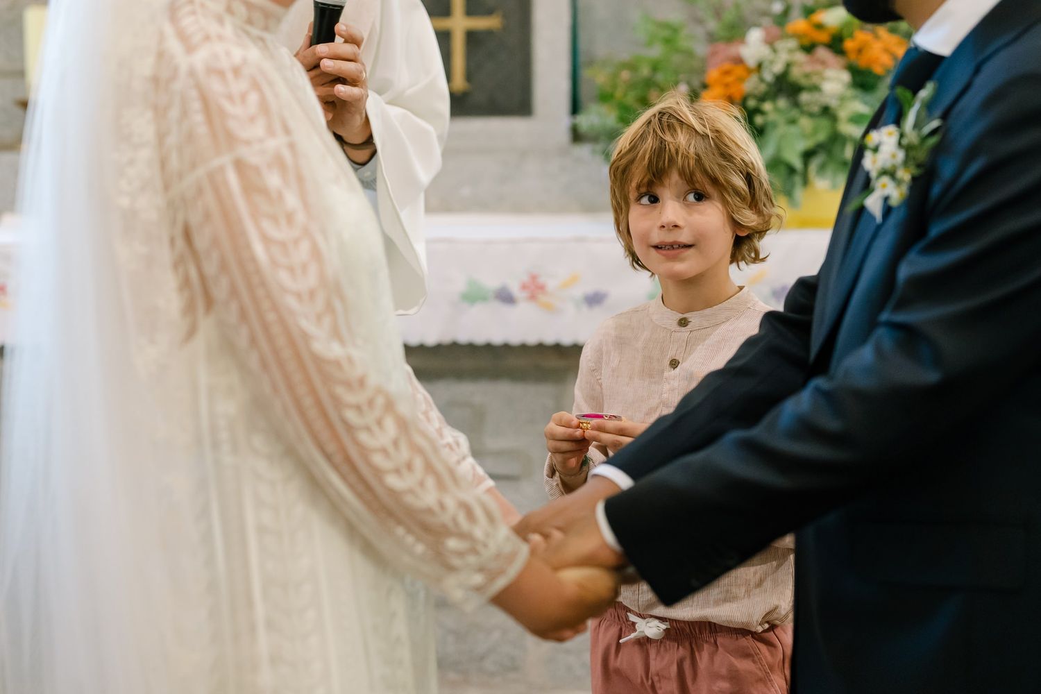 Intimate wedding ceremony moment showing bride in lace dress and groom exchanging vows.