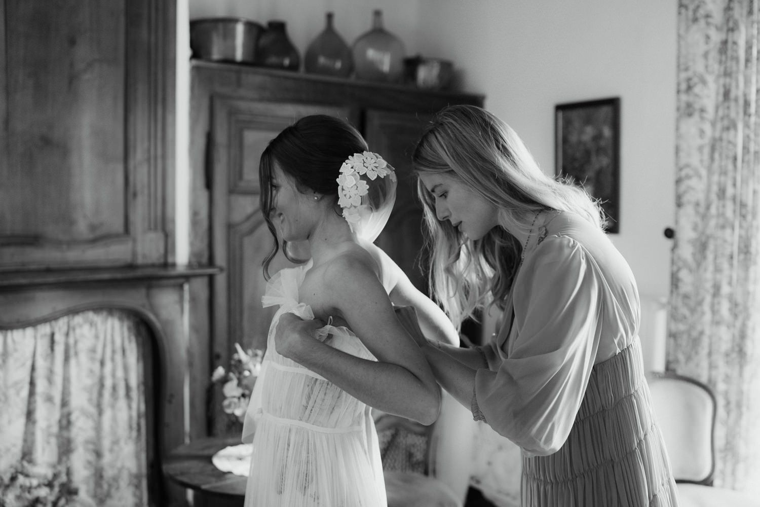 Wedding preparation moments captured through window light and floral curtains.