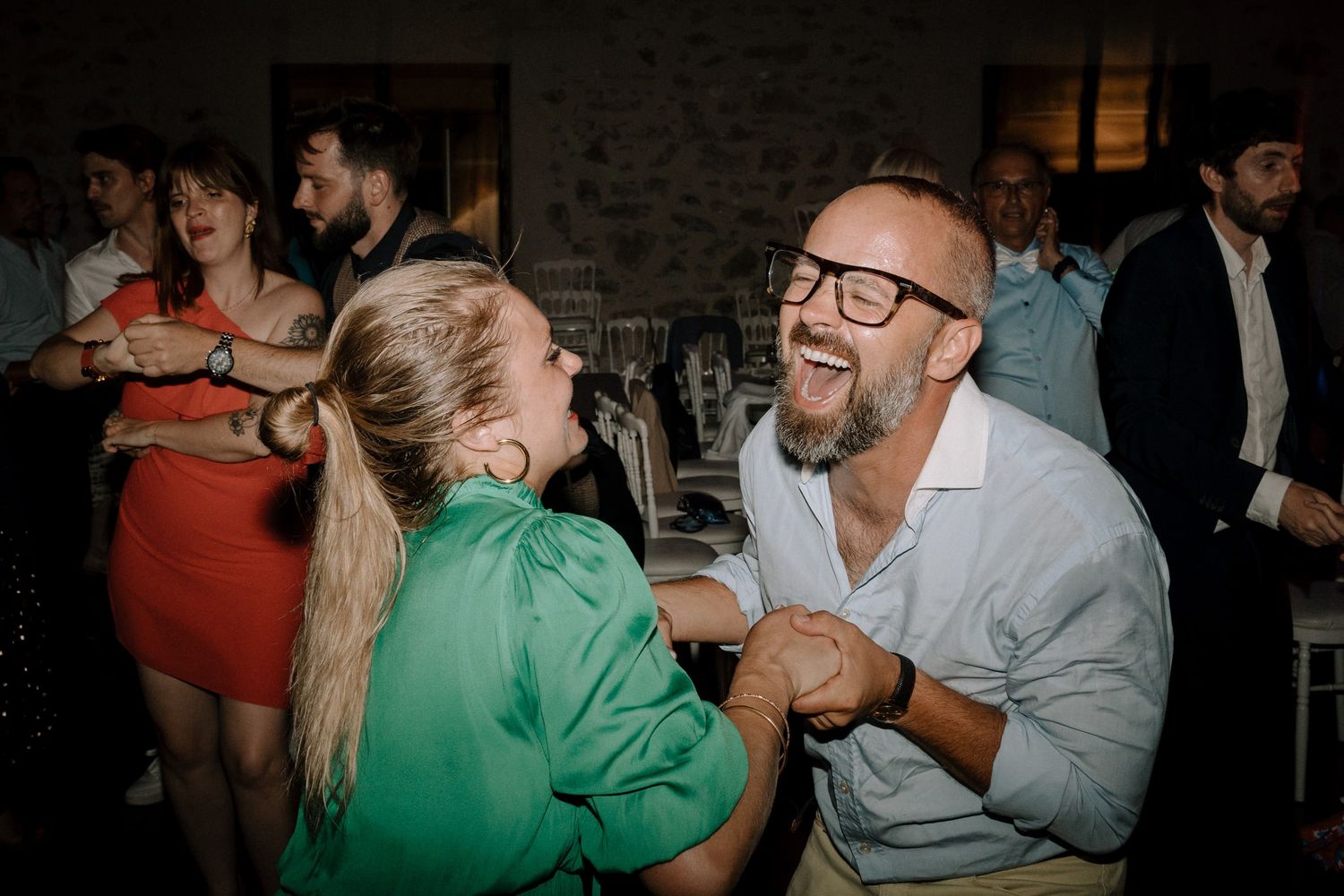 Romantic couple dancing and dipping during a dimly lit wedding reception celebration.
