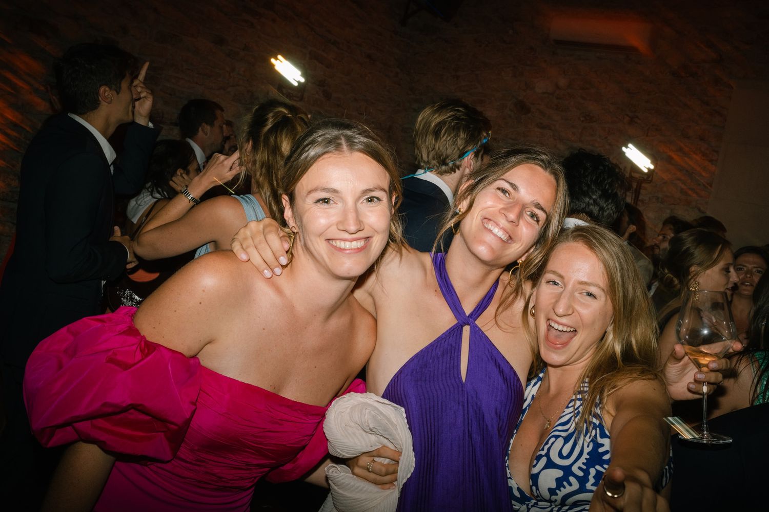 Wedding guests dancing and celebrating at a lively reception party.