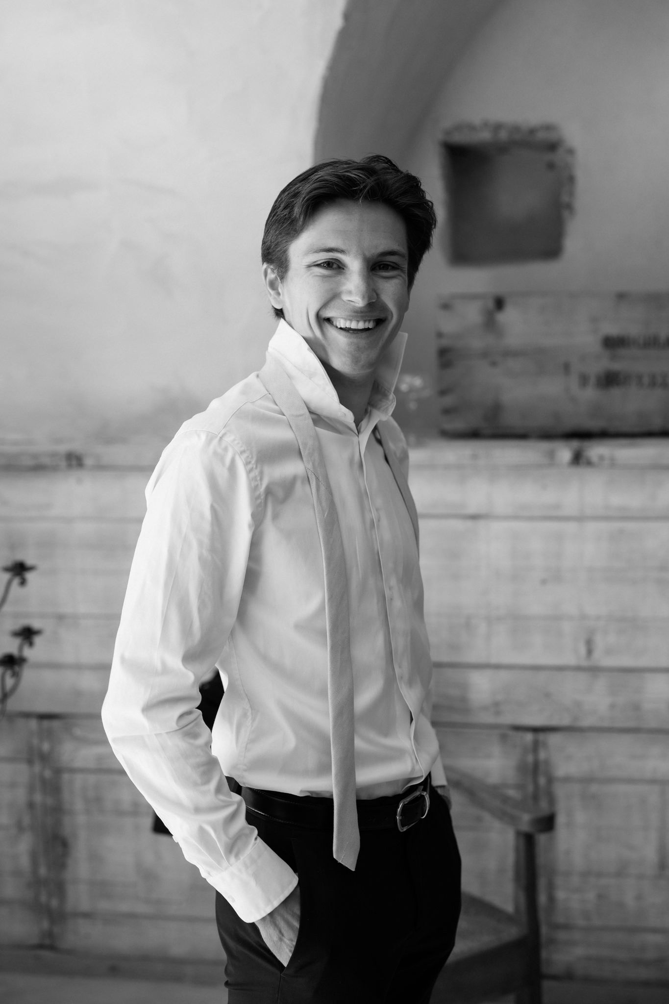 Black and white portrait series showing joyful expressions in a white shirt and tie.
