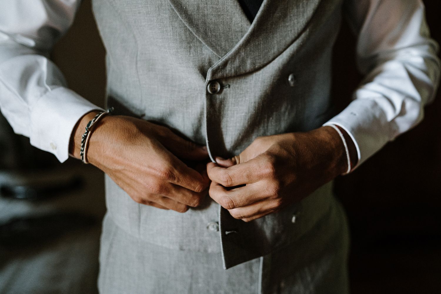 Detail shots of groom's formal attire and accessories in grey tones.