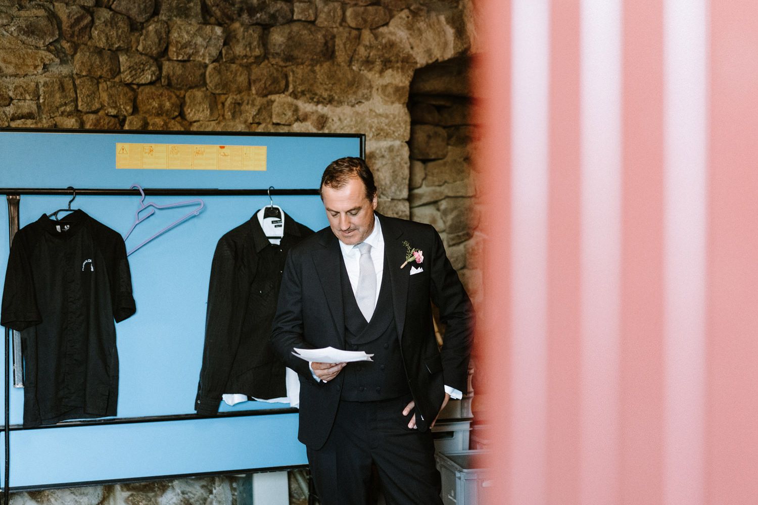 Pink and blue walls with formal attire displayed in a boutique or dressing room setting.