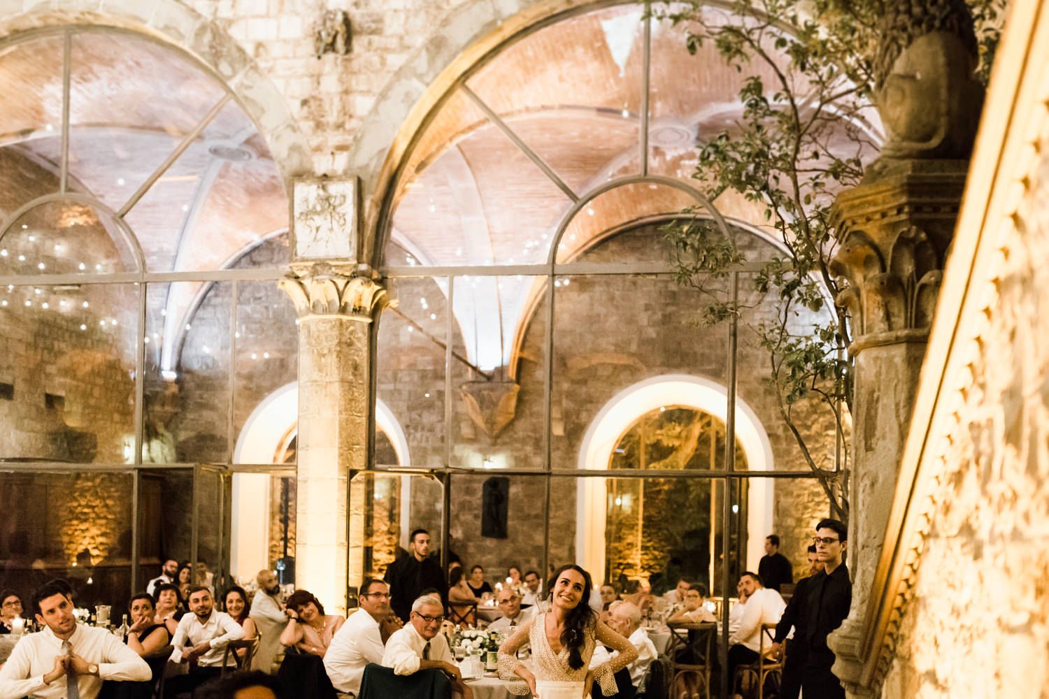 Panoramic view of a grand stone archway venue decorated for an elegant wedding reception.