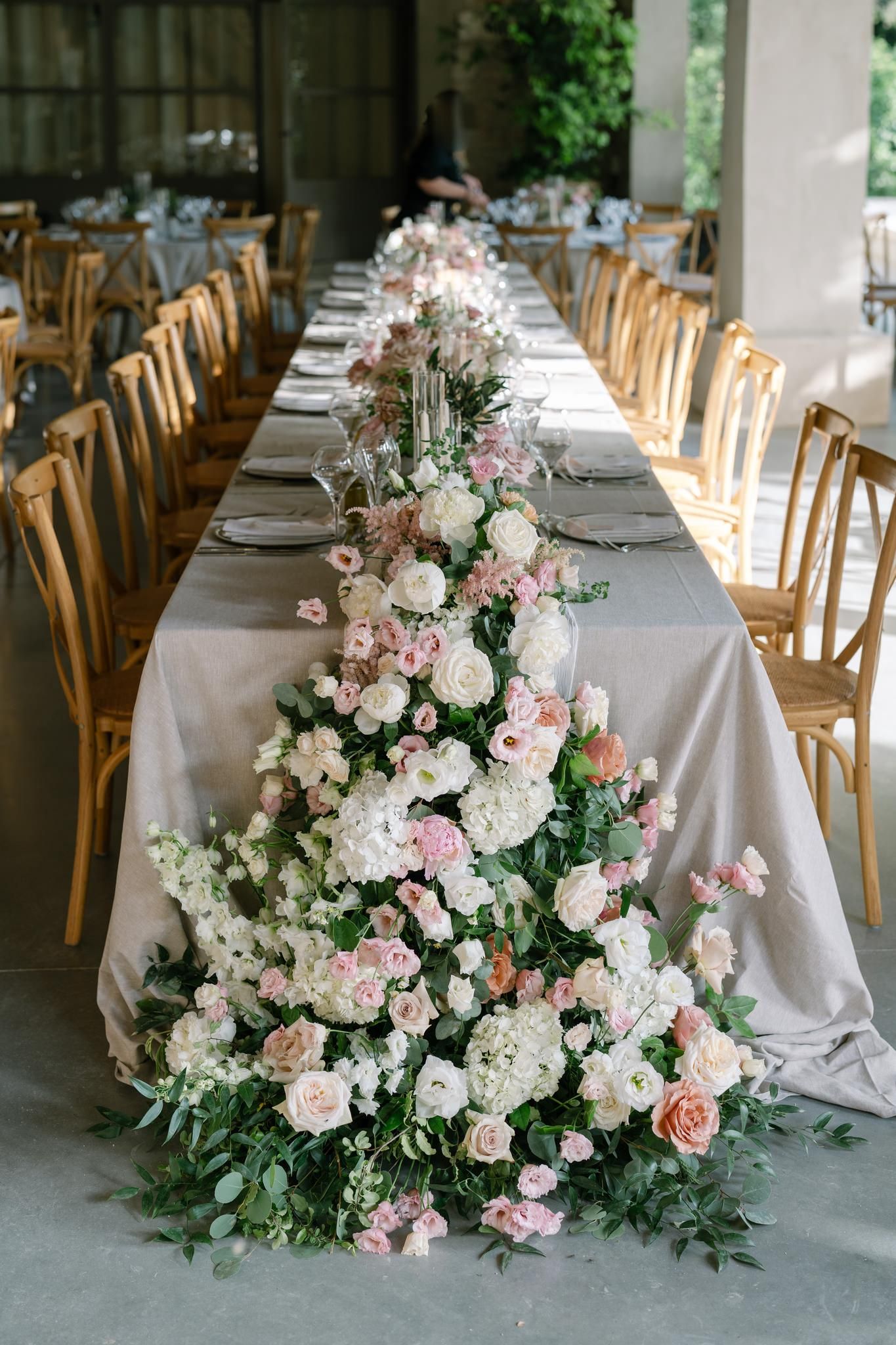 Luxurious wedding reception tables decorated with lush pink and white floral arrangements.