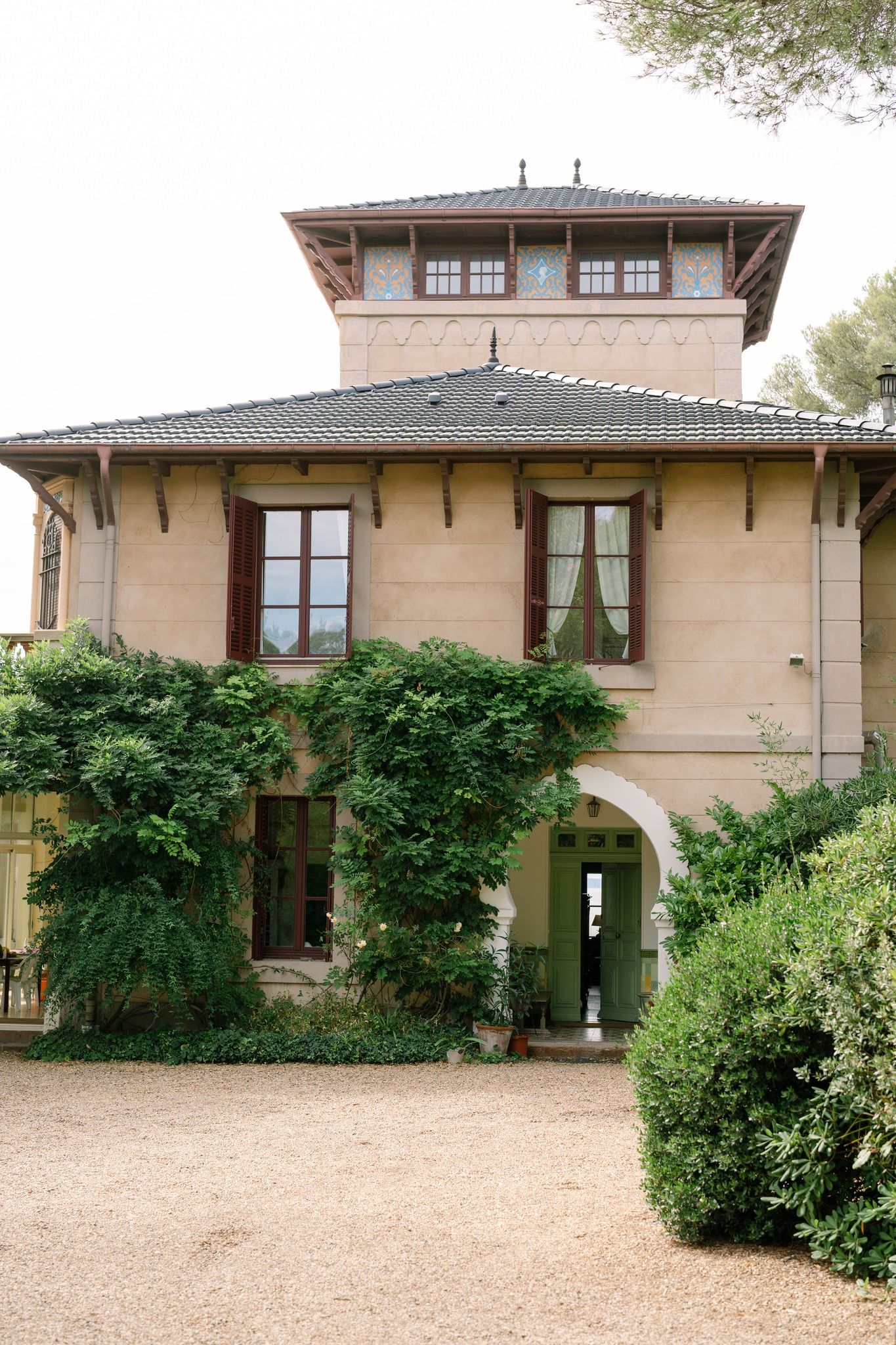 Mediterranean style villa with tan stucco exterior and lush greenery surrounding the property.