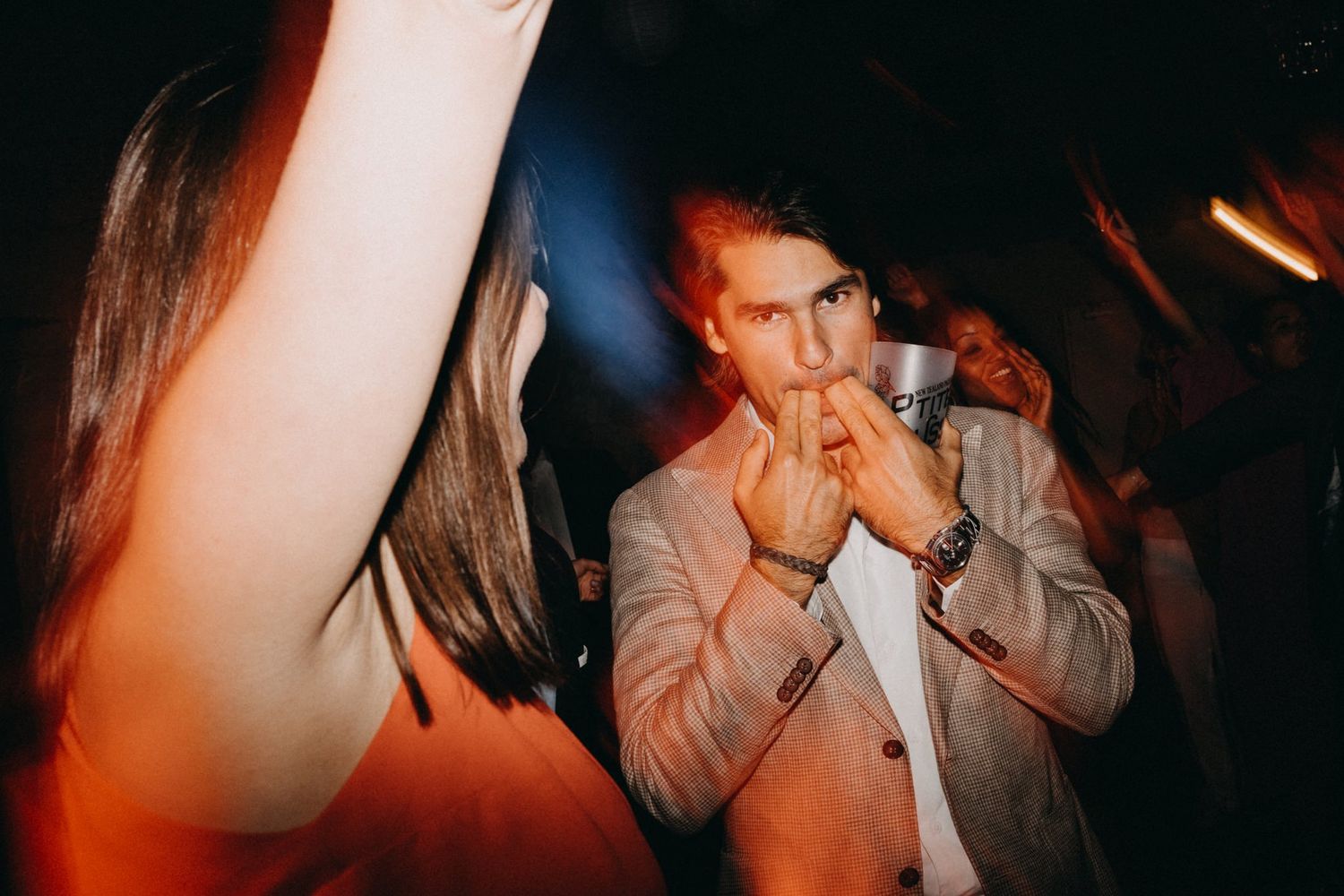 Wedding reception party with warm lighting and guests dancing in formal attire.
