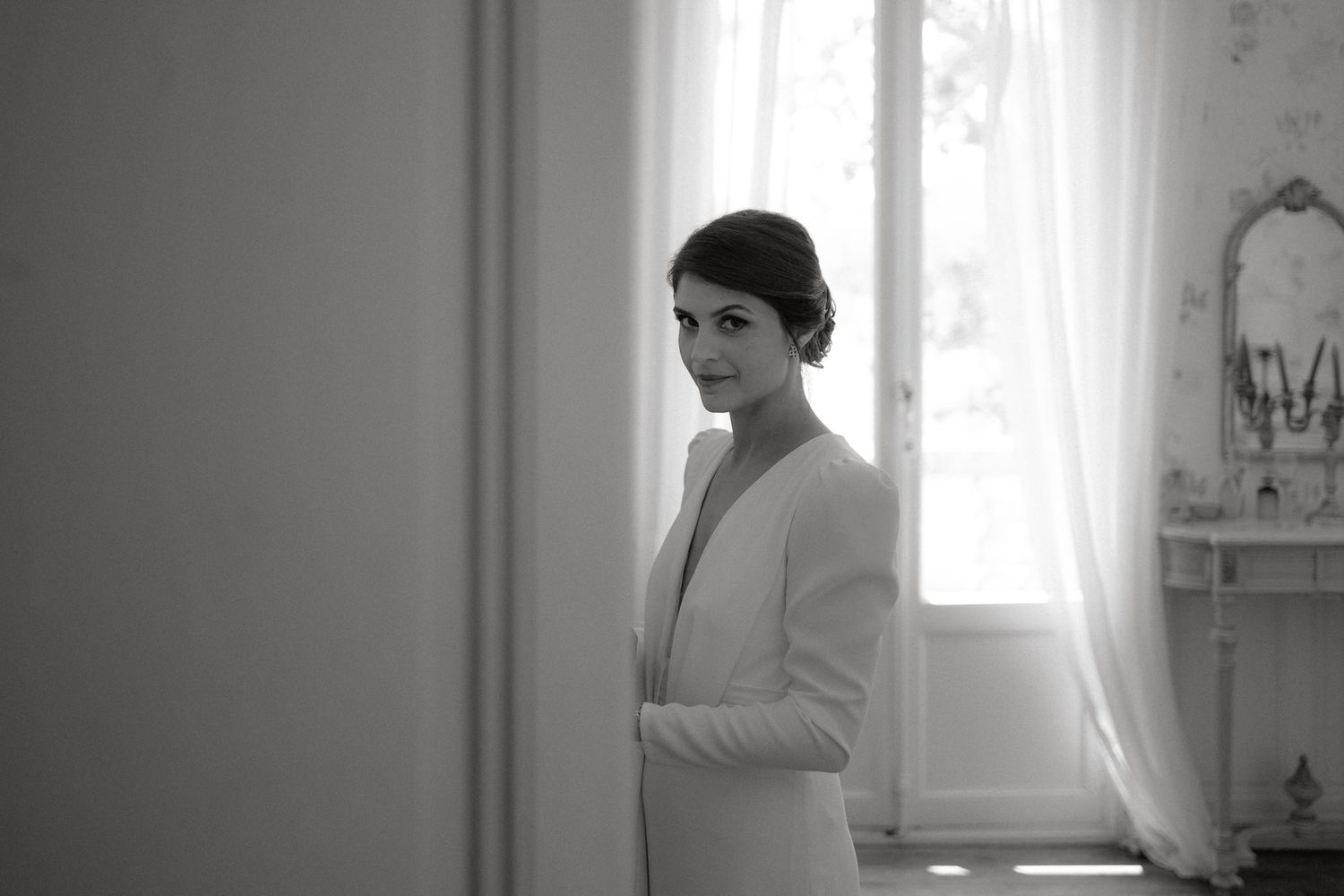 Minimalist black and white window portrait in bridal preparation room.