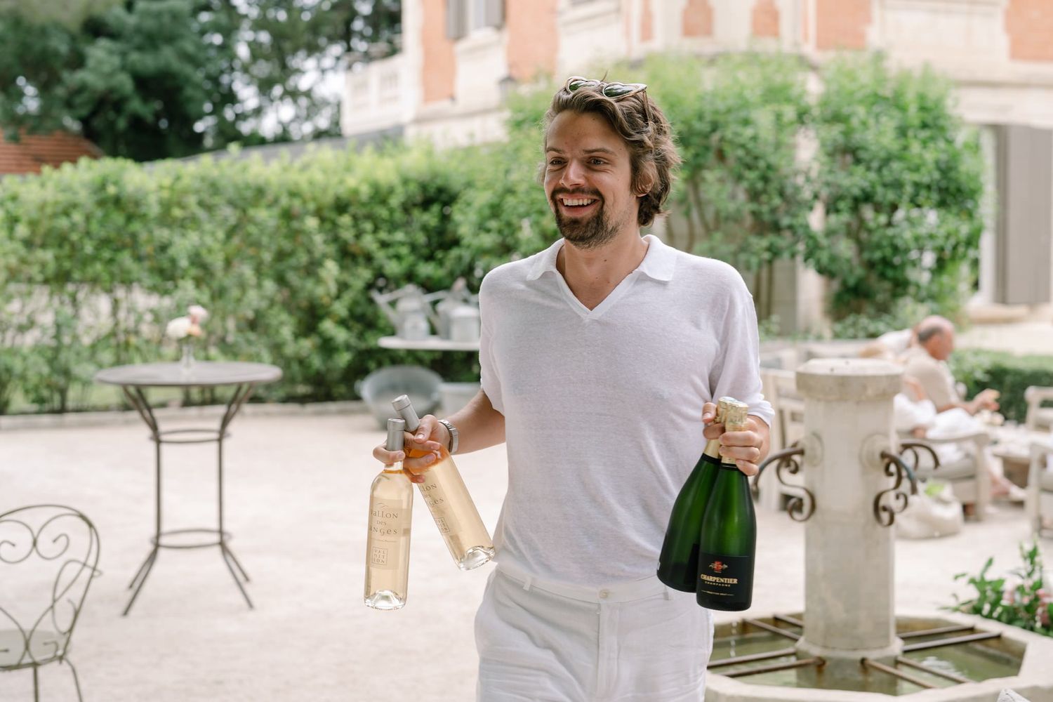 People celebrating with champagne outdoors on a sunny patio.