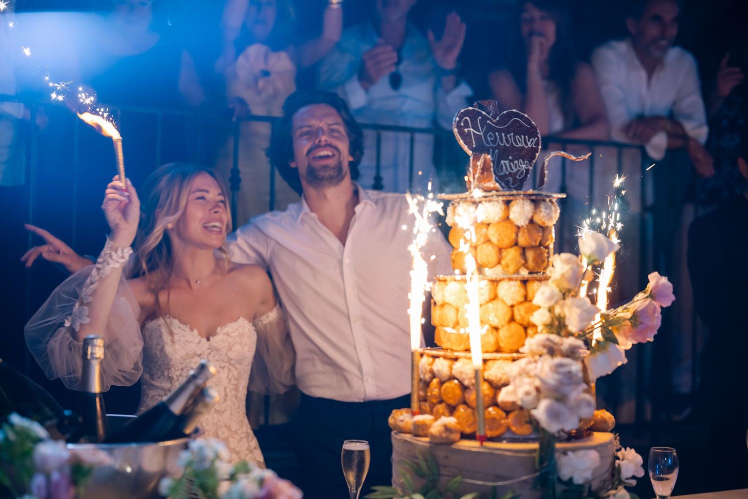 Wedding reception celebration with sparklers illuminating a joyful dance floor scene.