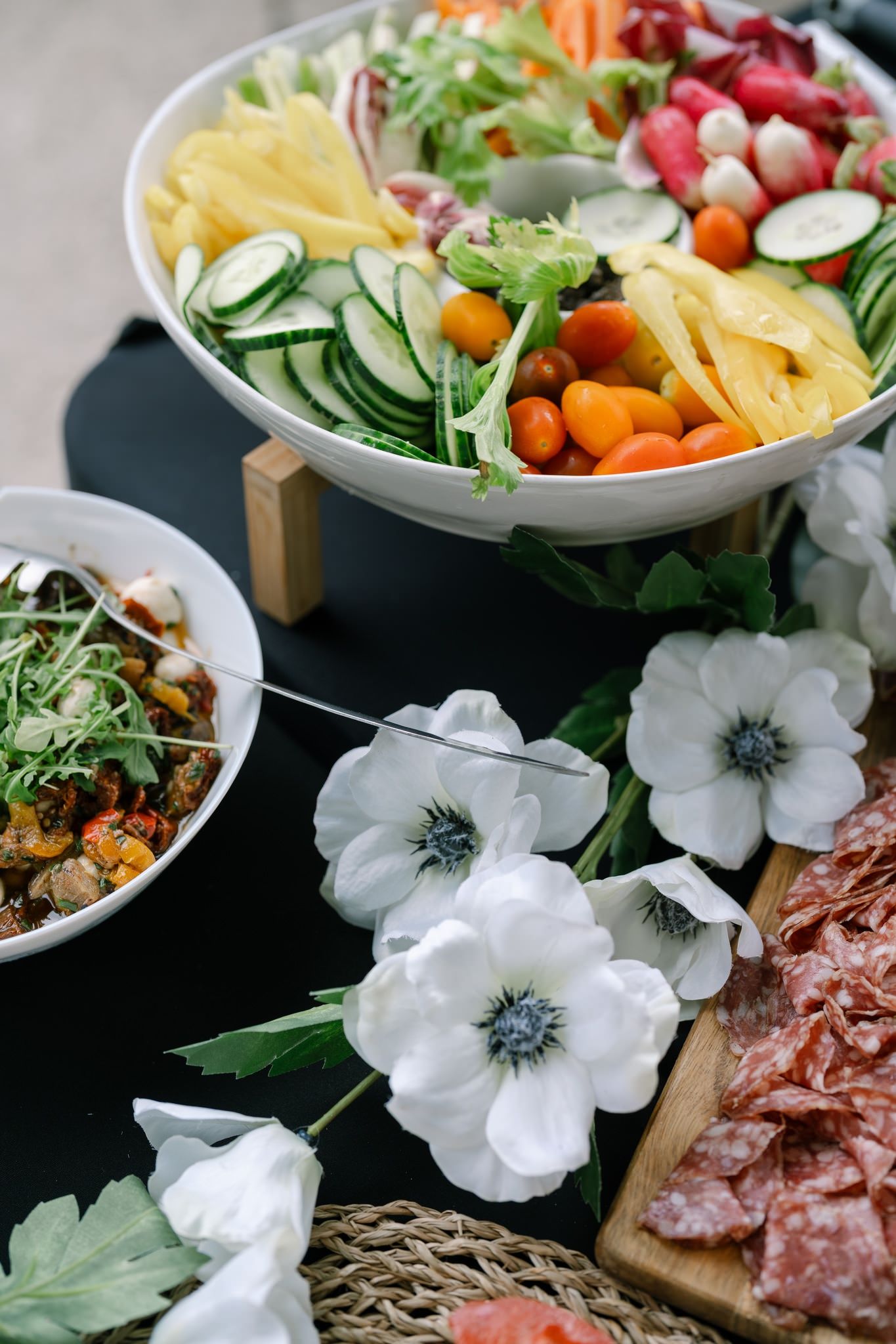 Beautifully arranged food platters decorated with white anemone flowers.