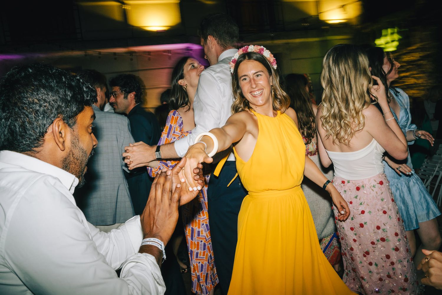 Wedding guests dancing and celebrating in formal attire.