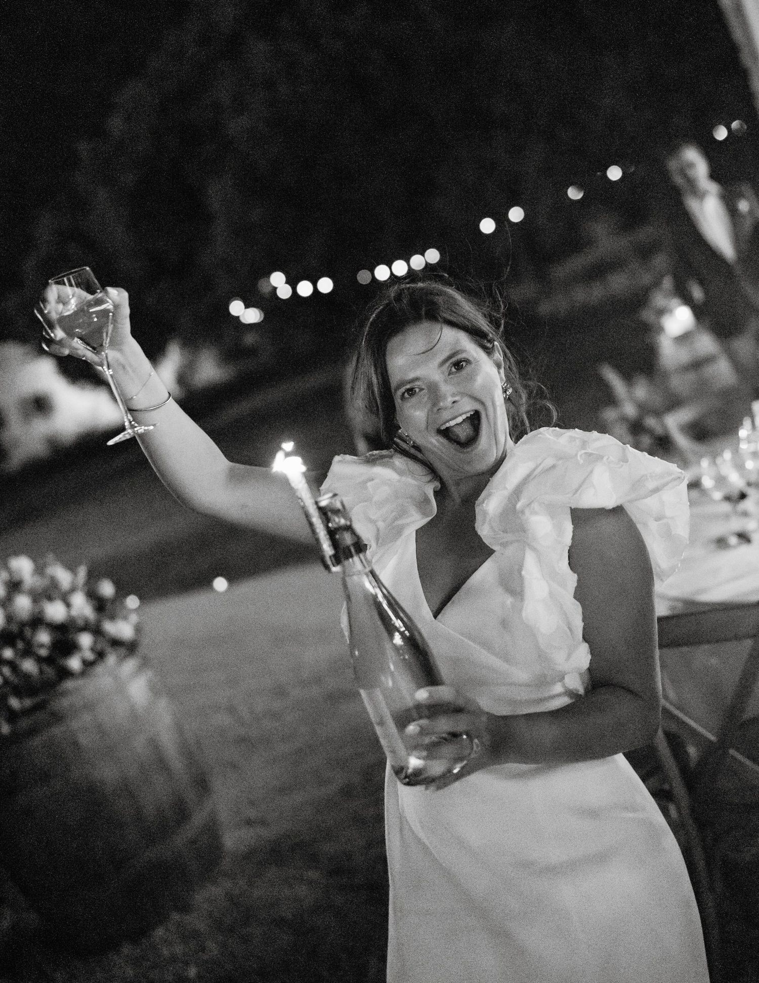Black and white photo of joyful dancing at nighttime celebration.
