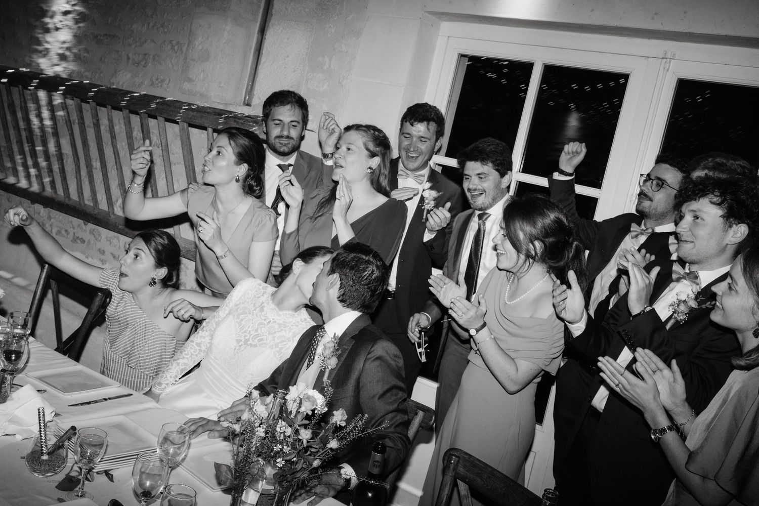 Wedding guests dance and celebrate on a crowded dance floor at a reception party.