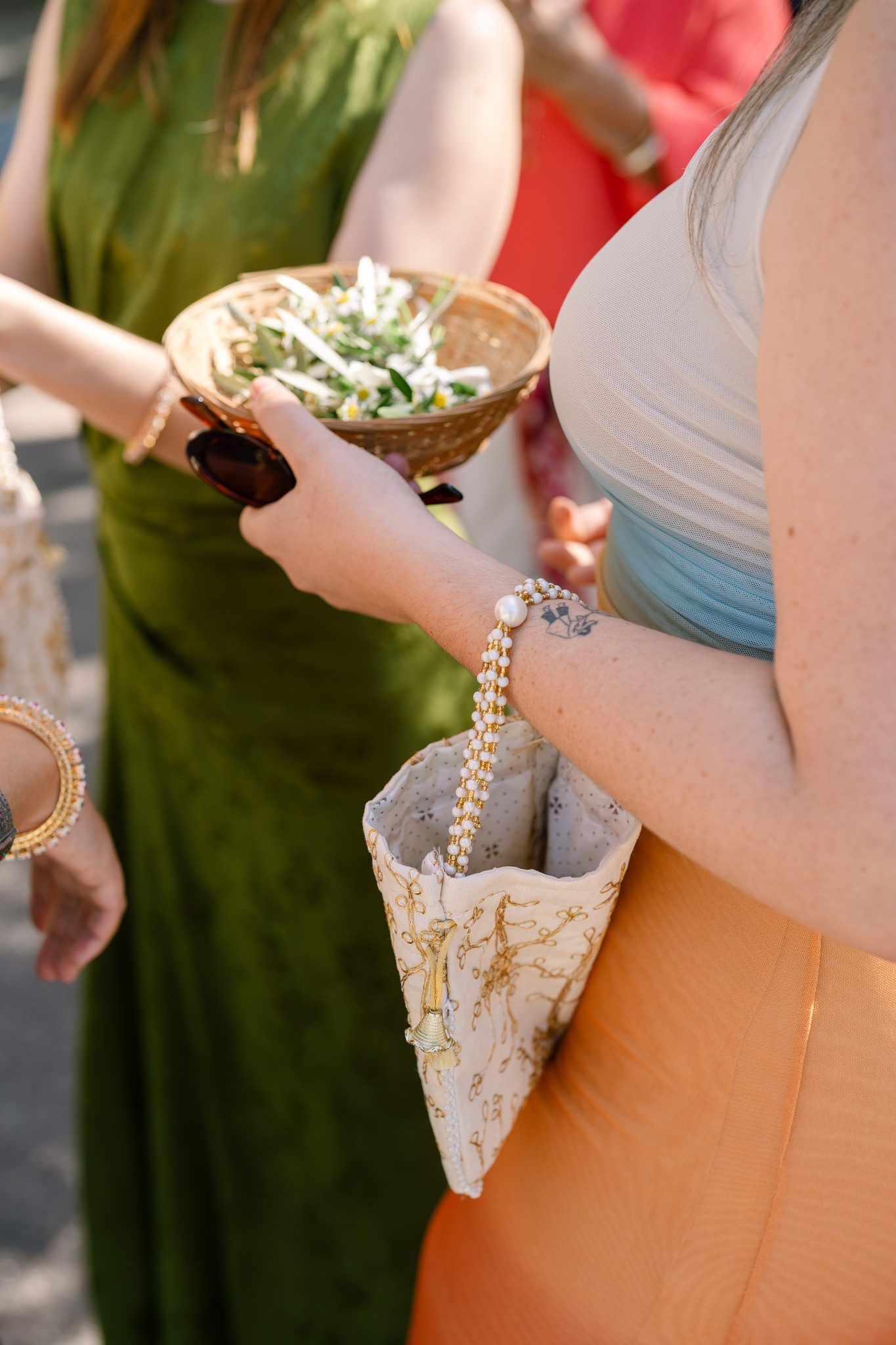 Wedding attendees in colorful dresses standing together at an outdoor event.