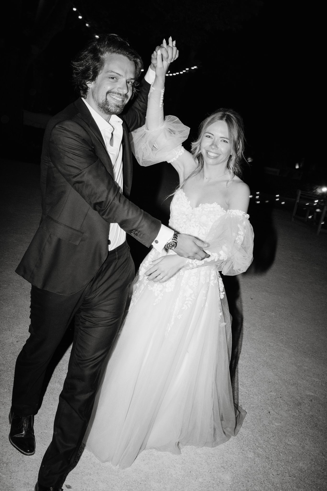 Joyful dancing moment captured in black and white at an evening celebration.