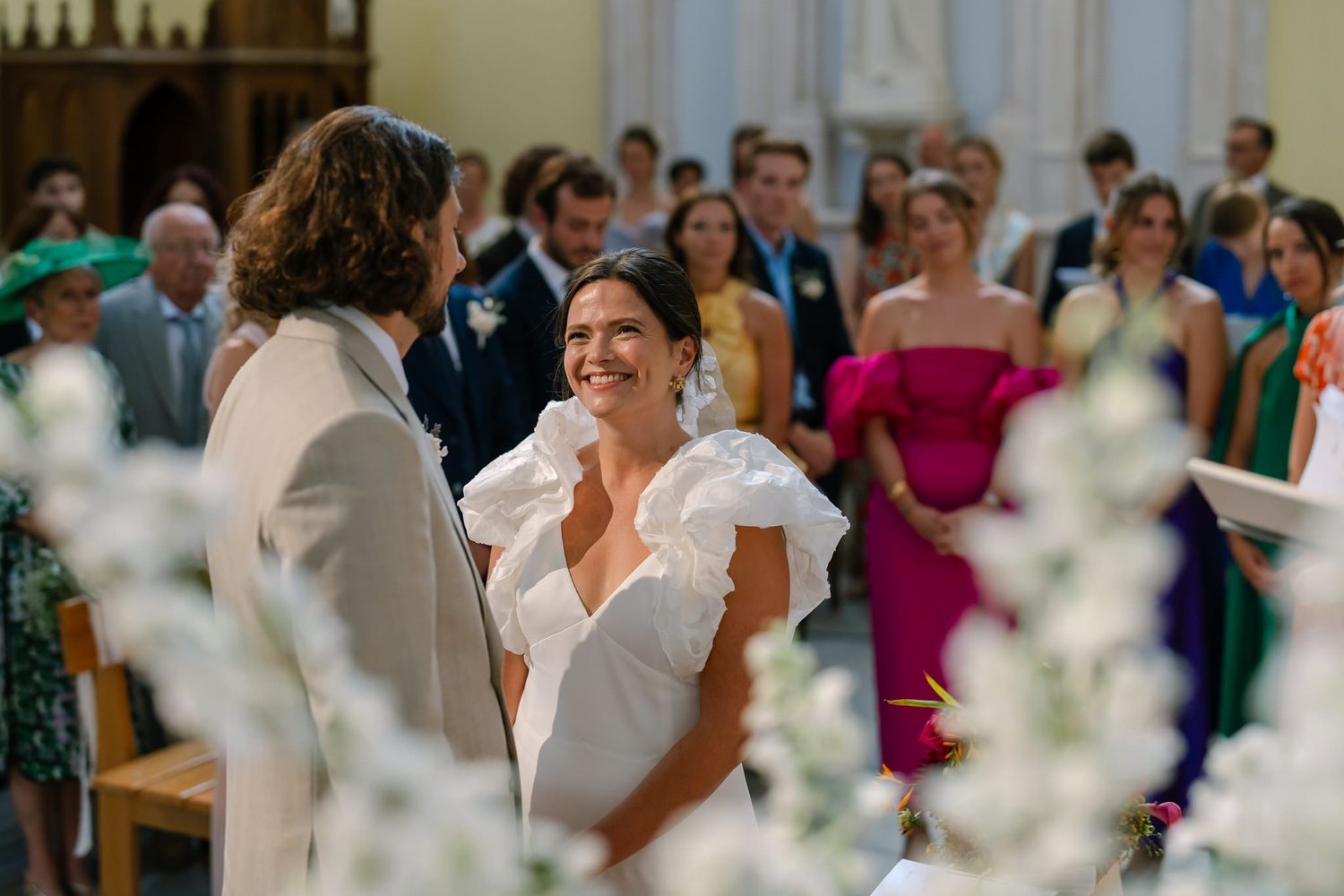 Couple sharing a tender moment during their wedding ceremony in a beautifully decorated church.