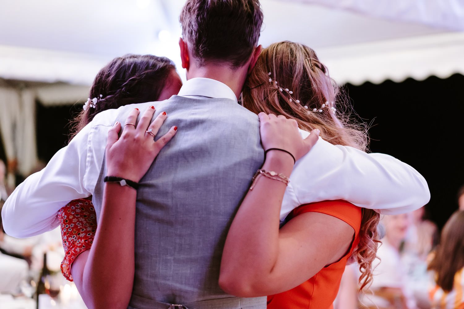 Wedding guests dancing together in pairs at an outdoor reception venue.