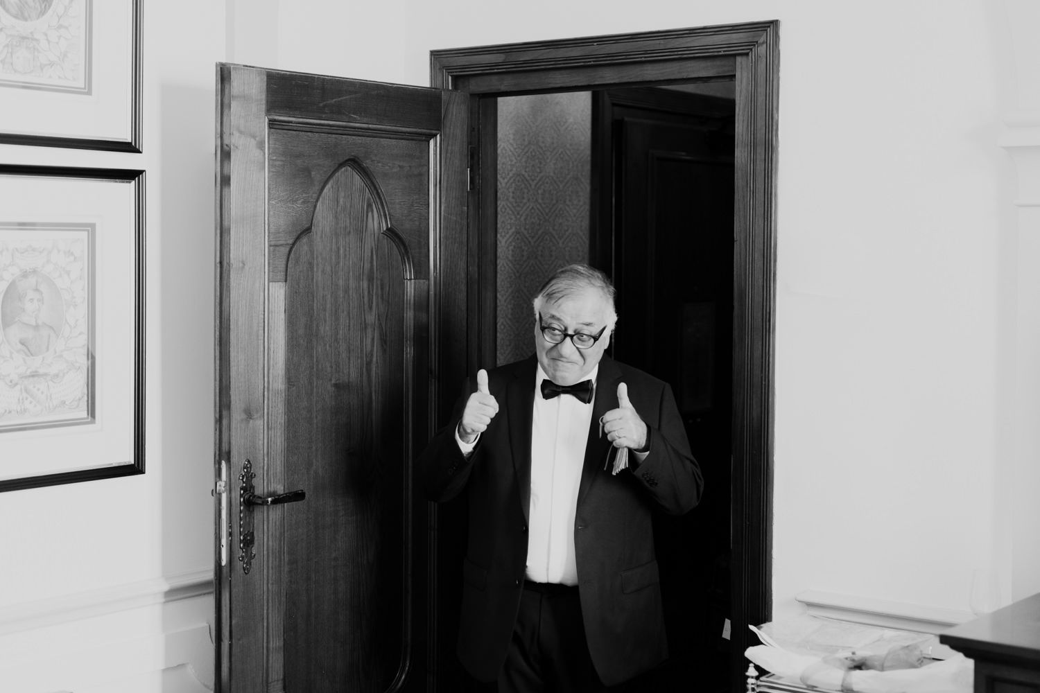 Black and white photo of a gentleman in a bowtie gesturing enthusiastically.