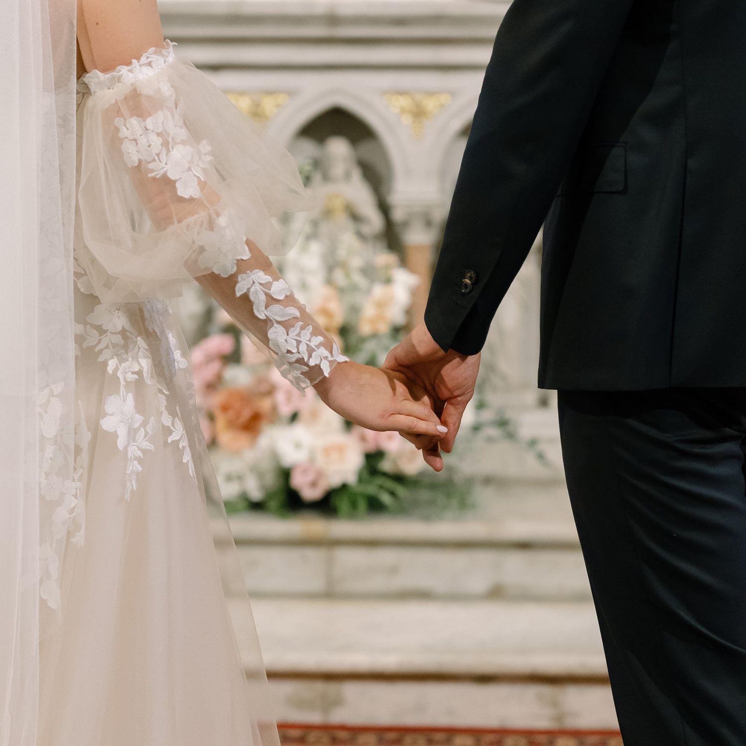 Close-up details of wedding dress lace and formal attire during church ceremony.