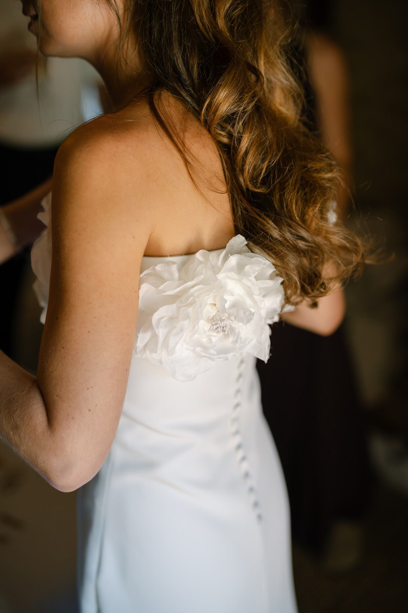 Detail shot of a white wedding dress with ruffled bodice and delicate embellishments.