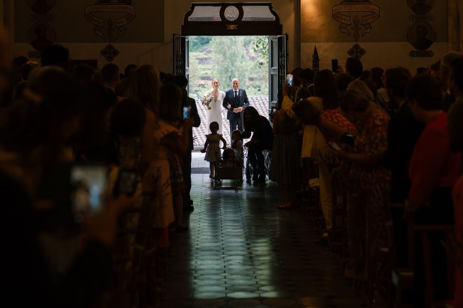 Dark hallway with silhouettes of people walking through church corridor.