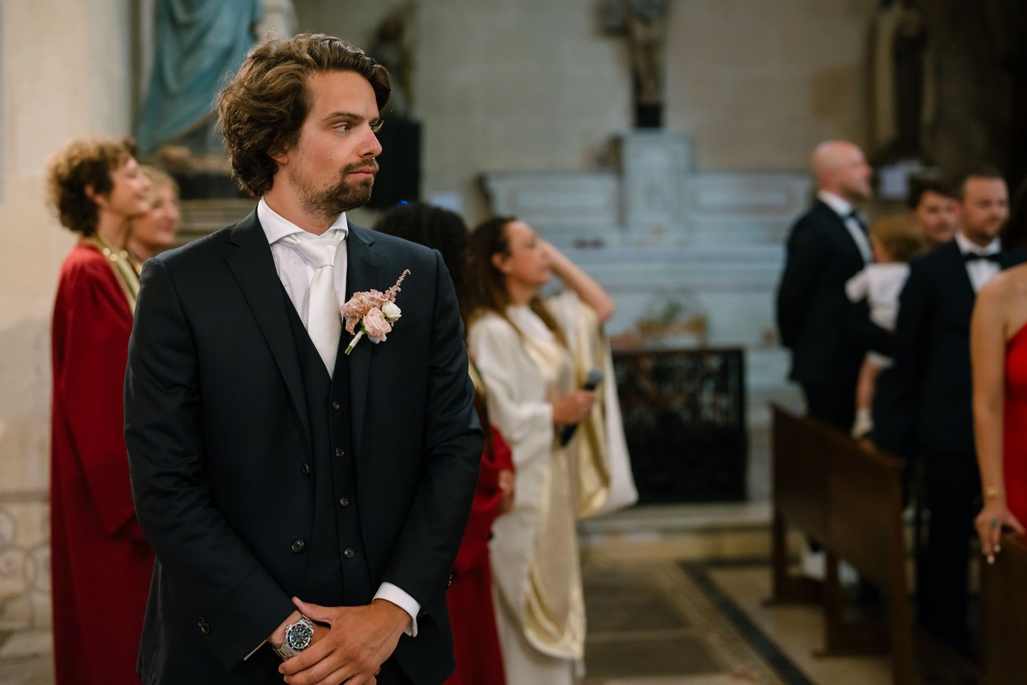 Wedding guests gathered inside an elegant church during a ceremony.