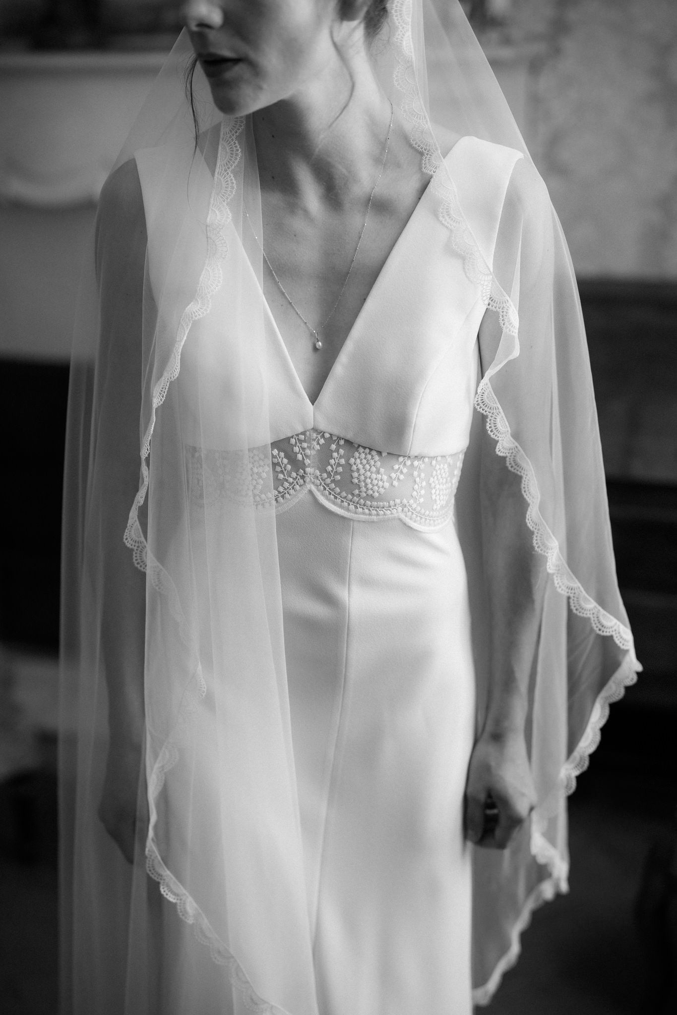 Elegant white wedding dress bodice with lace details and sheer veil.