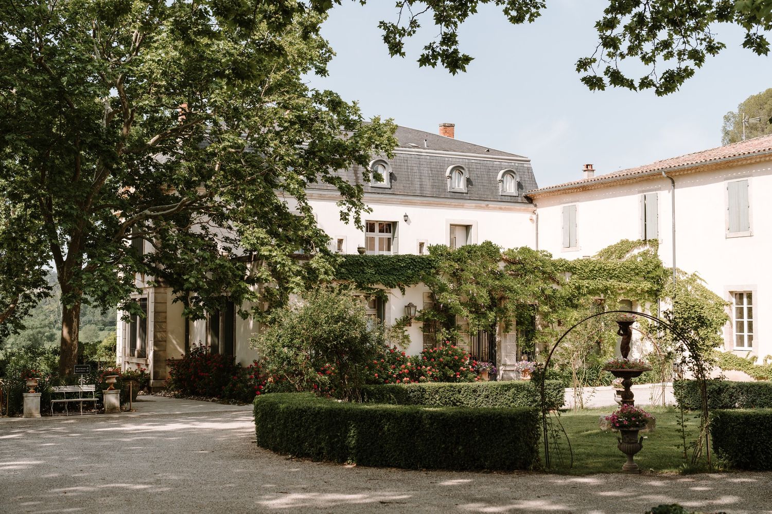 Elegant French chateau garden with manicured landscaping and tree-lined paths.