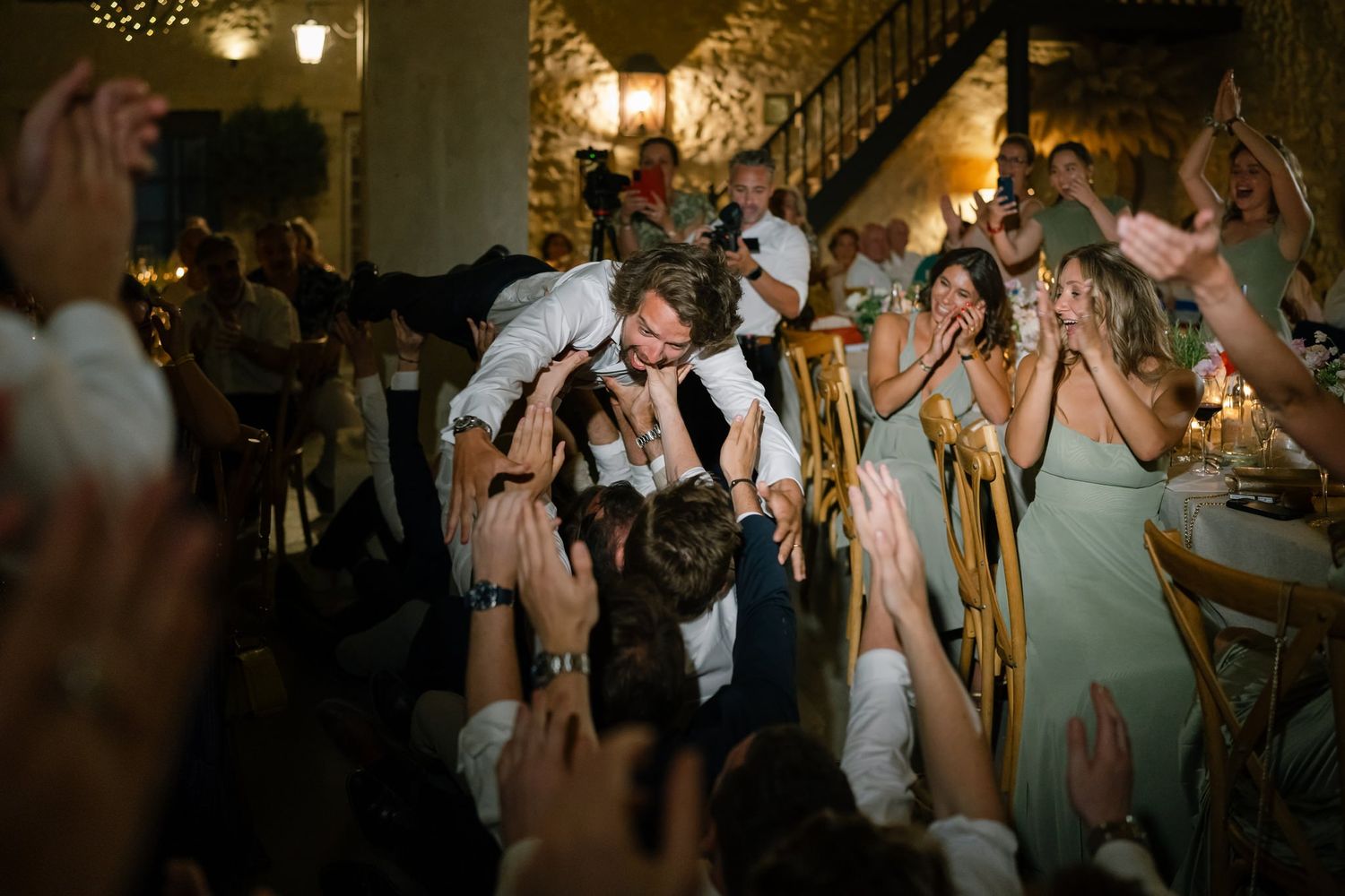 Wedding reception dance floor filled with celebrating guests under twinkling lights.