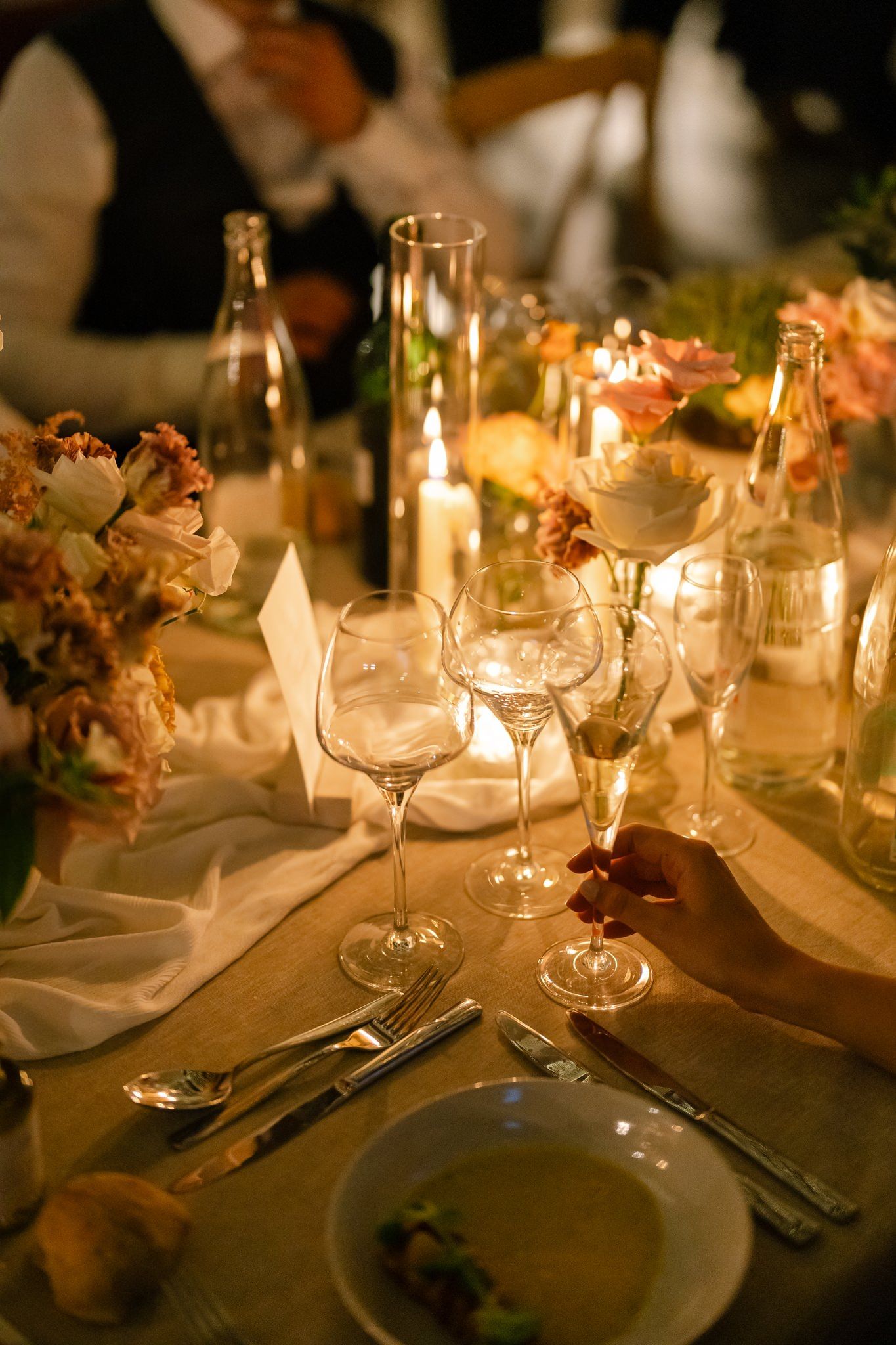 Intimate candlelit dinner table with wine glasses and elegant place settings.