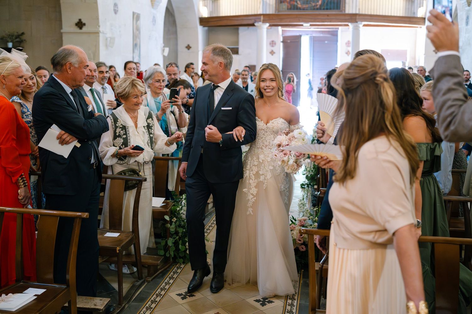 Wedding ceremony guests seated in wooden pews inside a traditional church.