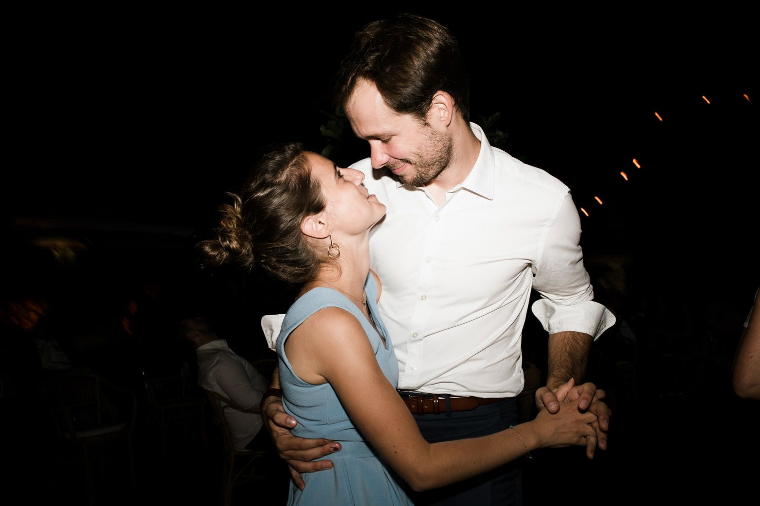 Couples dancing closely together during a romantic slow dance at an evening celebration.