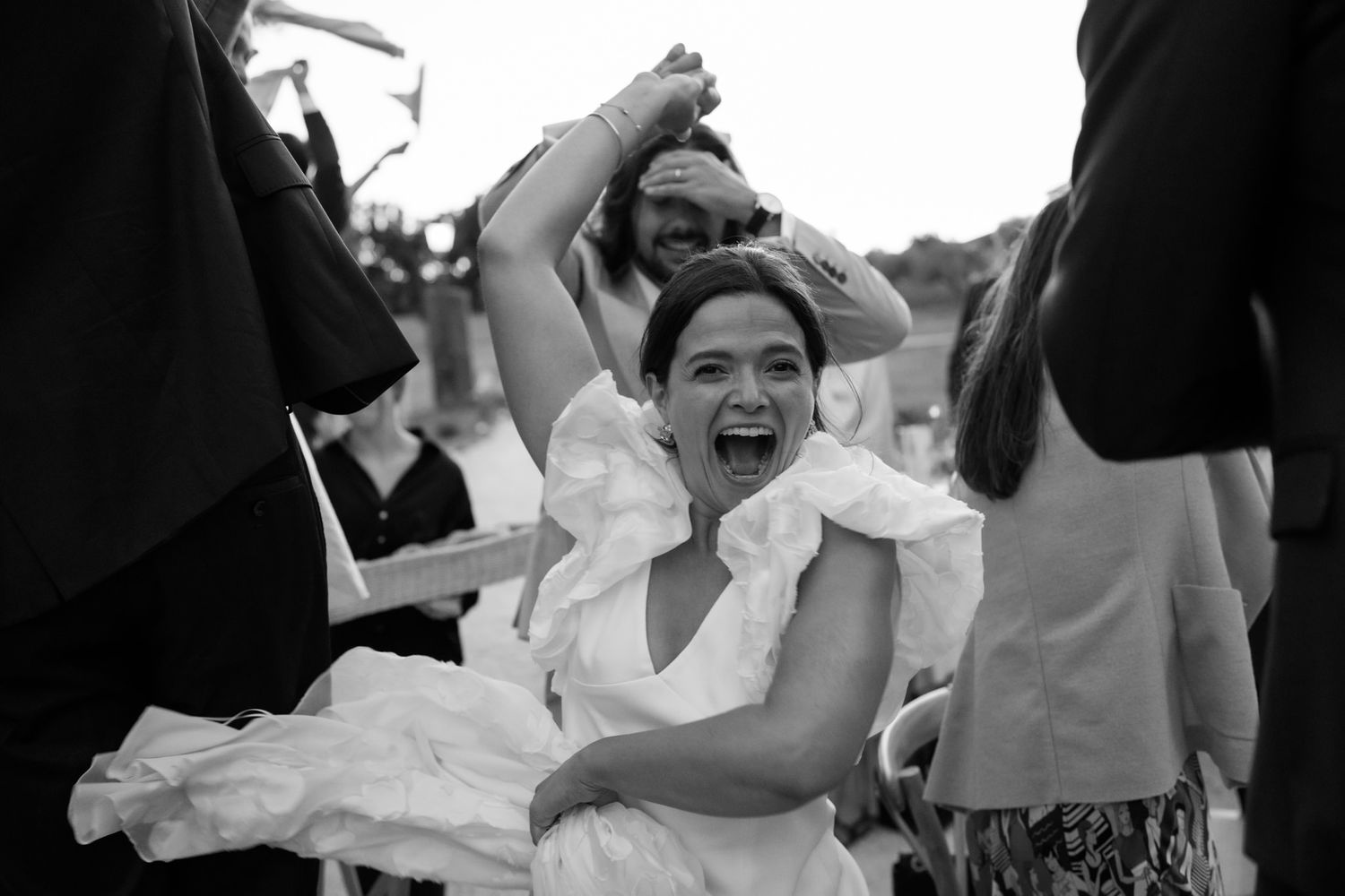 Wedding guests dance energetically during an evening reception celebration.