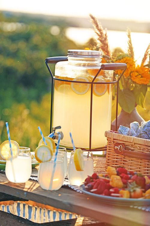Outdoor party setup with mason jar drinks and appetizers at sunset.