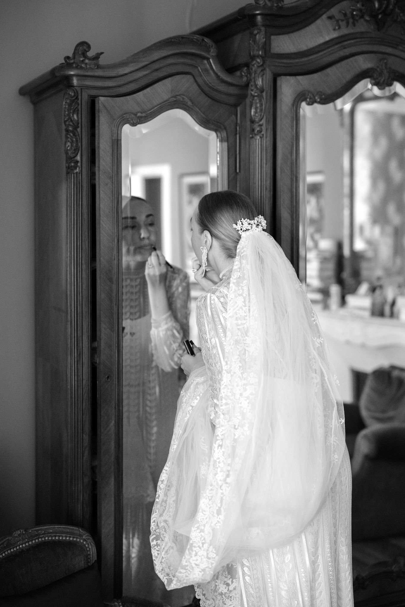 Elegant bridal portrait reflected in ornate vintage armoire mirror.