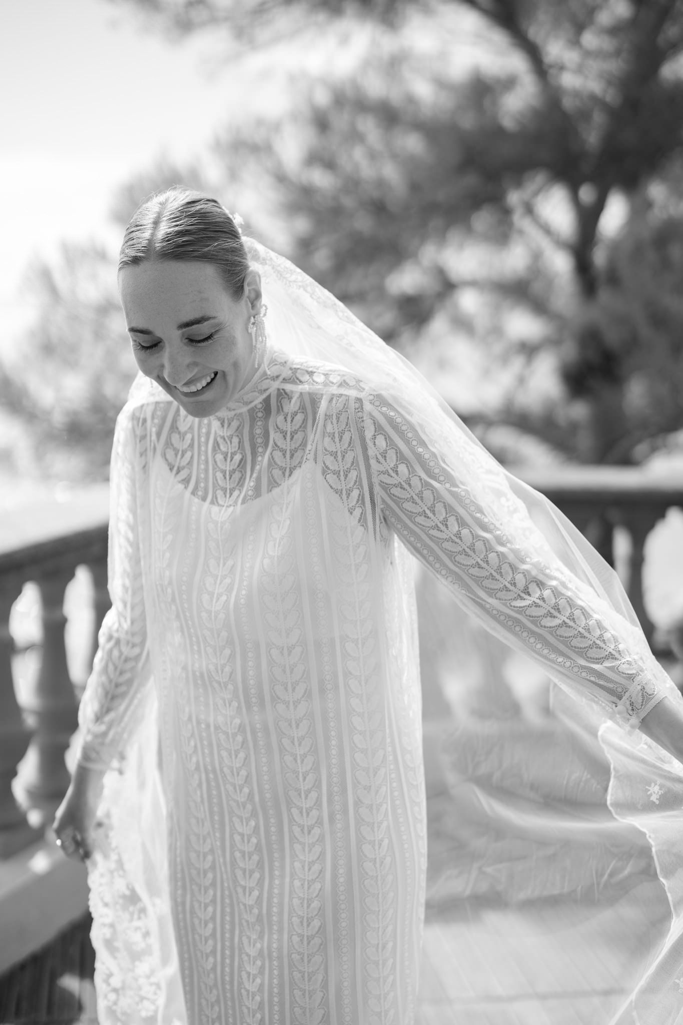 Close-up details of an elegant white lace wedding dress with intricate patterns and long sleeves.