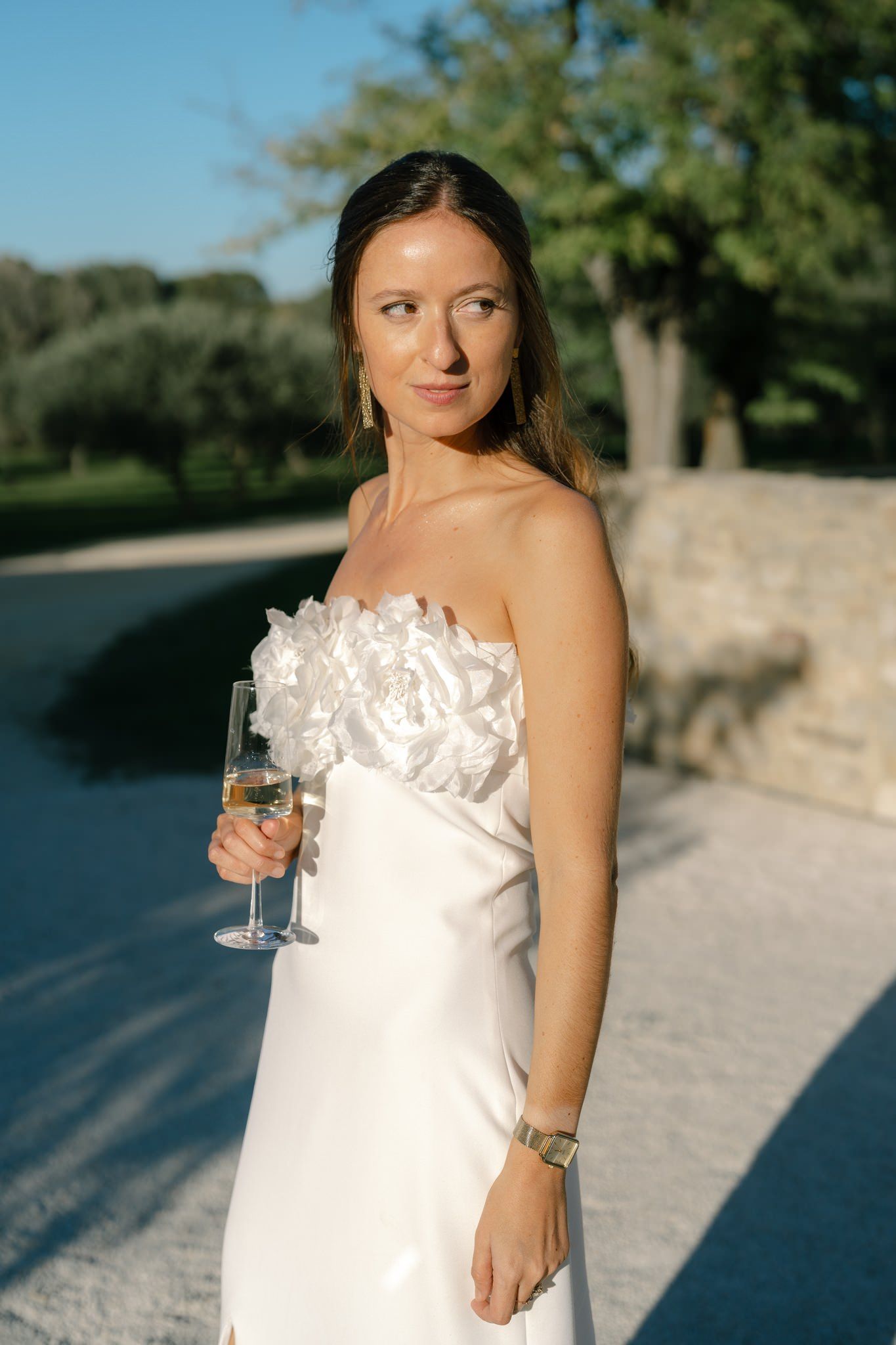 Elegant outdoor wedding reception setting at sunset with stone patio and natural landscaping.