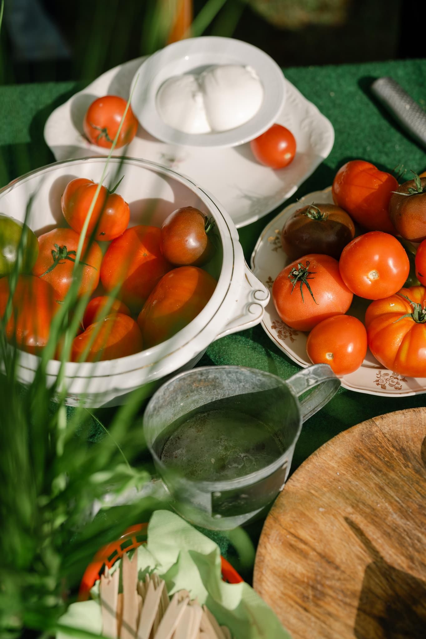 Fresh tomatoes and kitchen items arranged on a wooden surface.