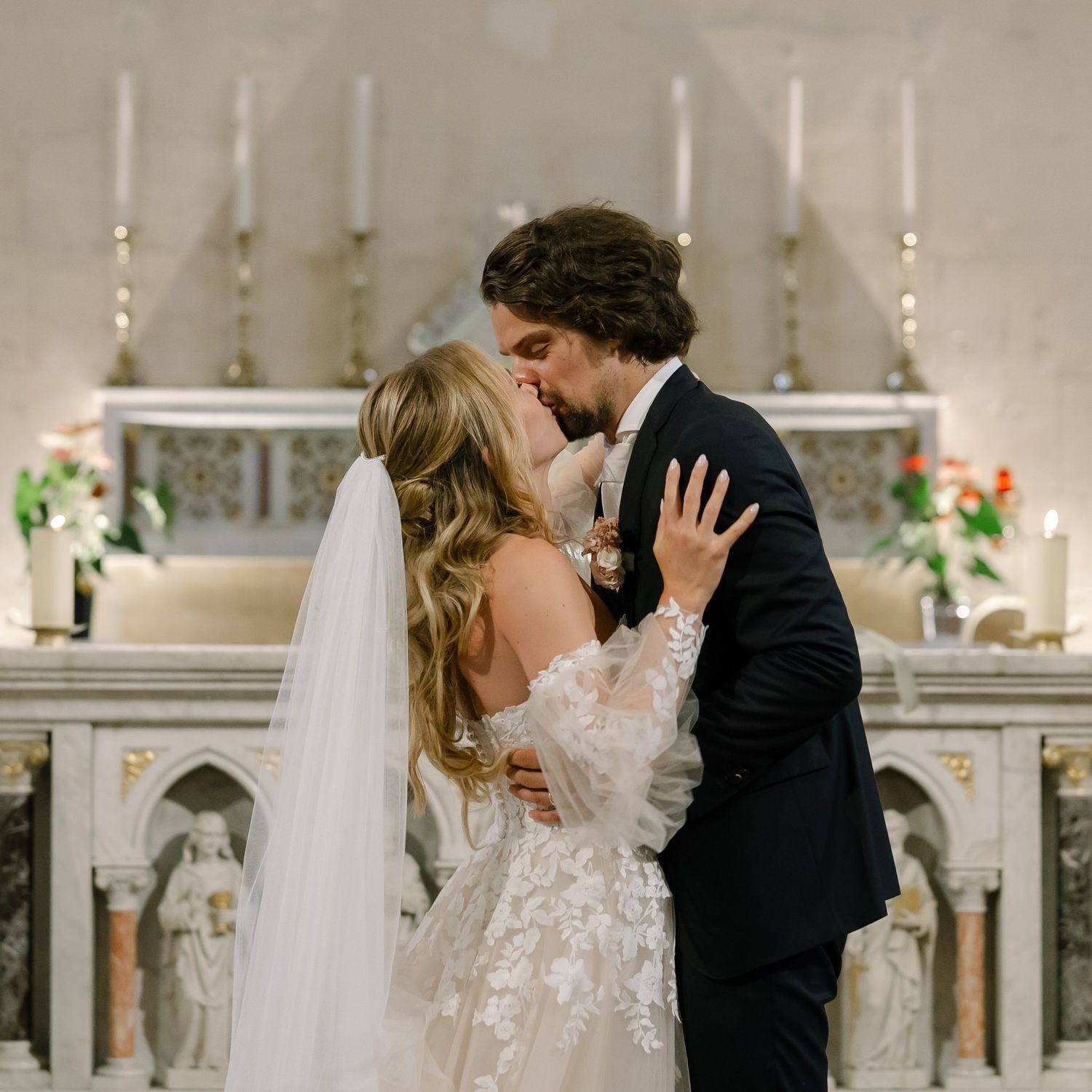 Romantic wedding ceremony moment at the altar in an elegant church setting.
