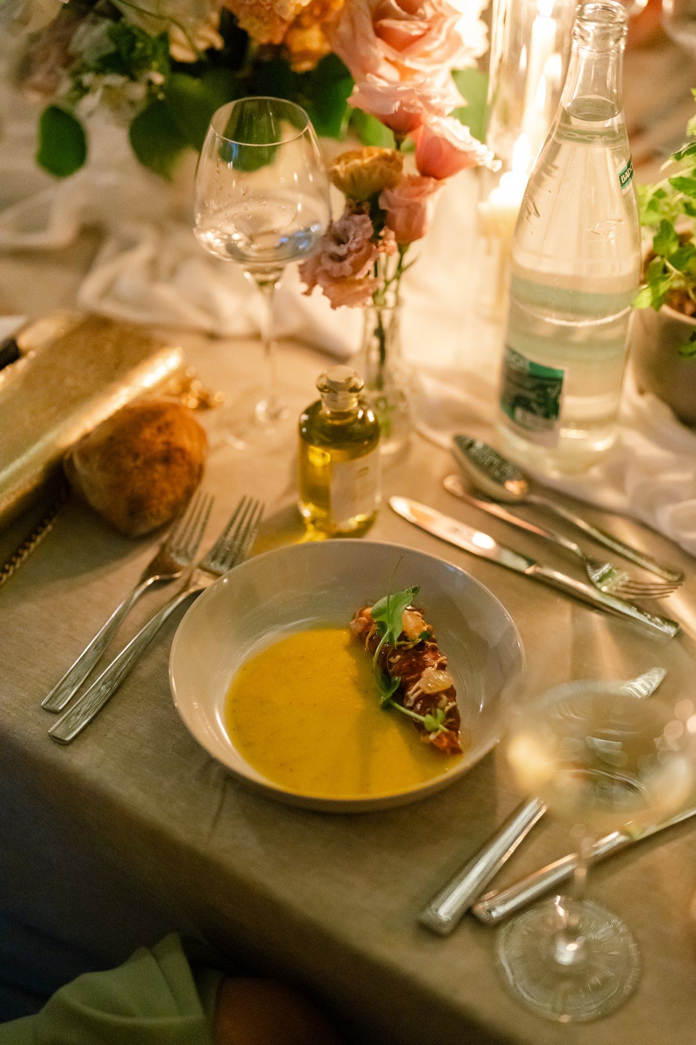 Gourmet soup course served on elegant table setting with soft candlelight.