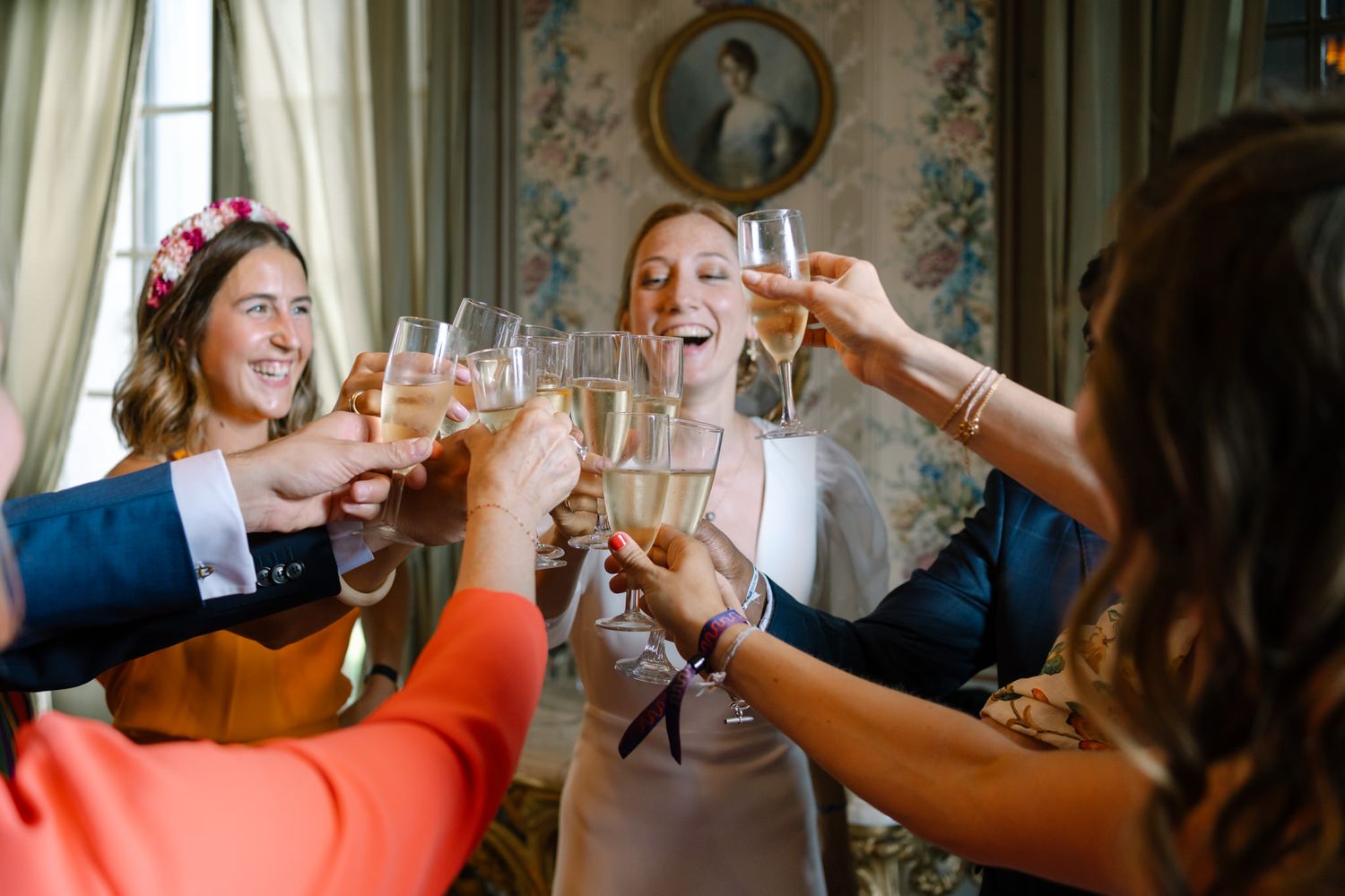 Wedding celebration toast with guests in elegant room with ornate decor.